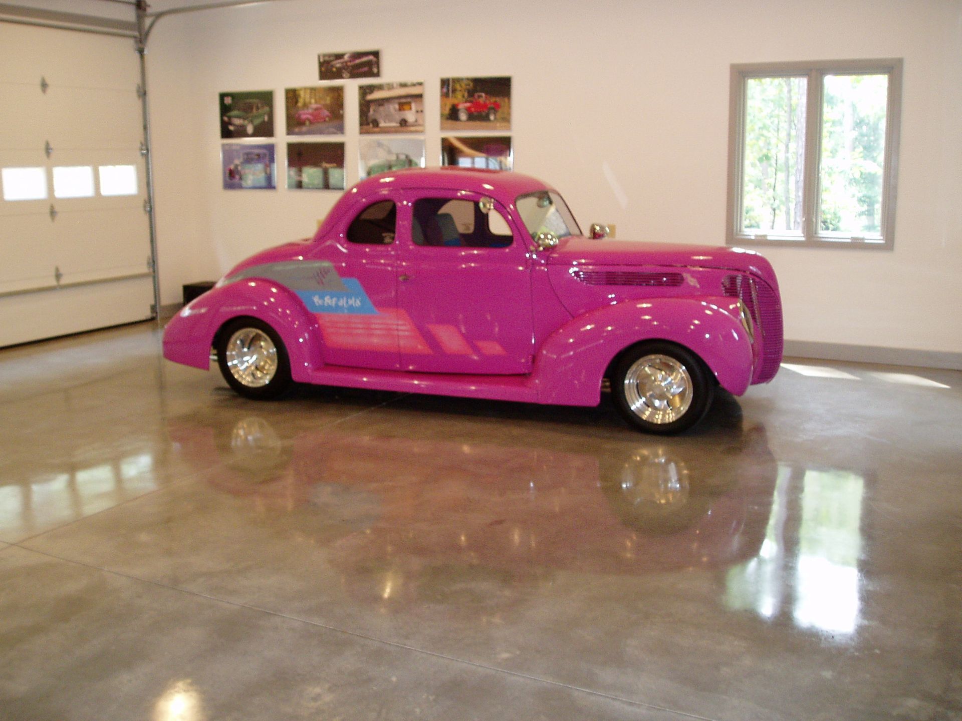 Pink classic car in a garage with polished concrete floor.