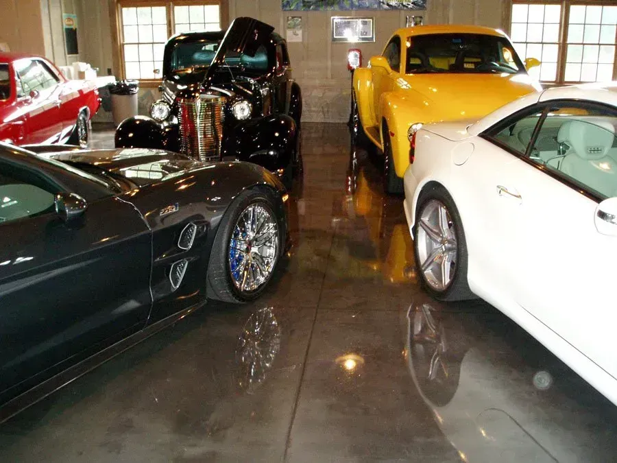 A collection of cars parked in a garage with a shiny floor.