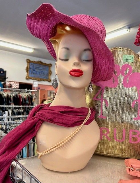 A mannequin wearing a pink hat and scarf