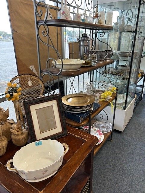 A room filled with lots of plates , bowls , and a picture frame.