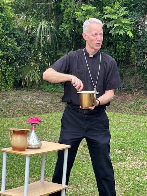A man in a black shirt is holding a gold bucket