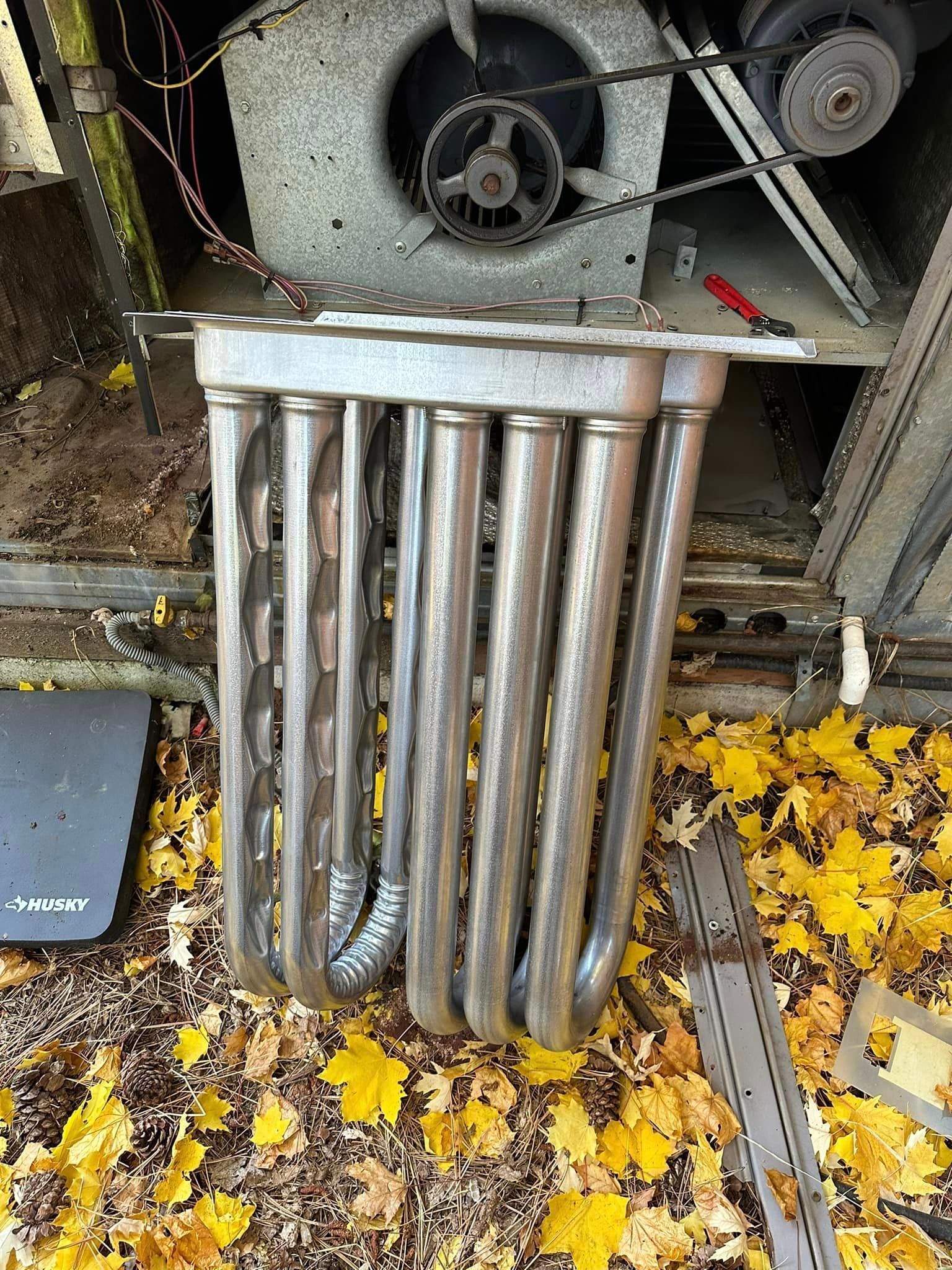 A metal heater is sitting on top of a pile of leaves.