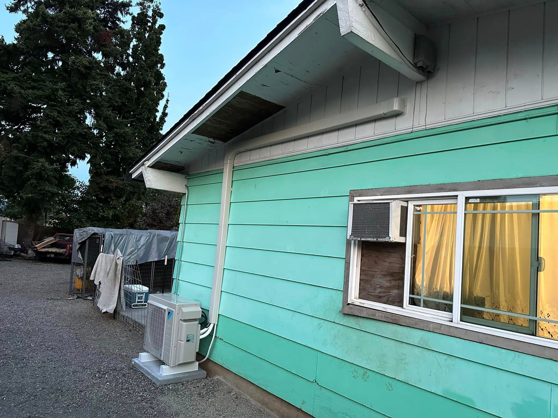 A blue house with a window and air conditioner on the side