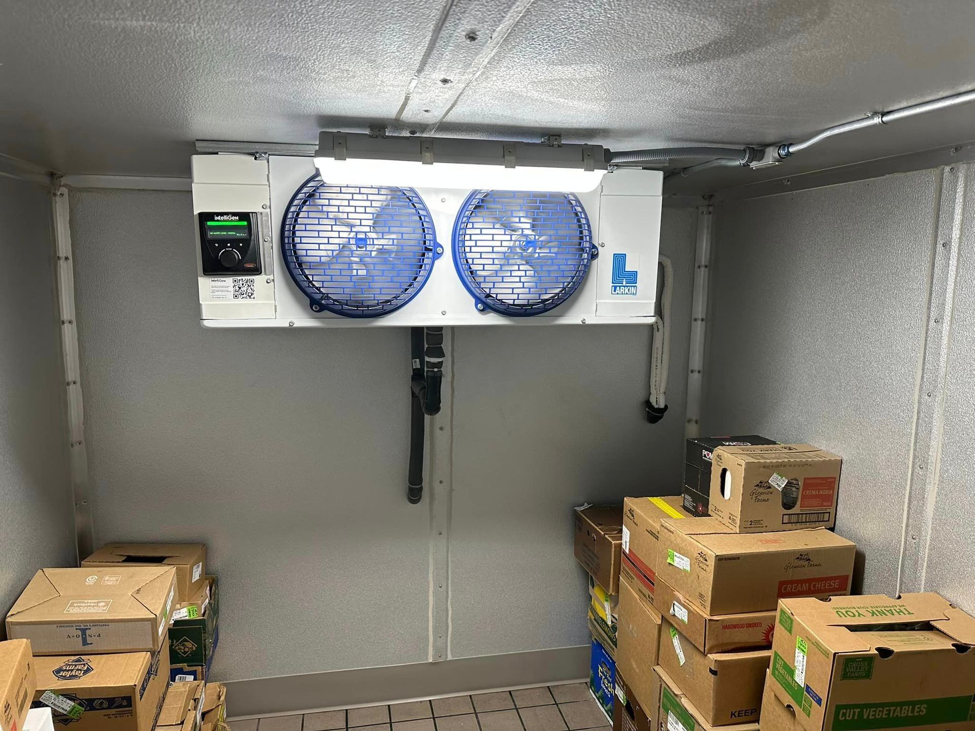 A room filled with boxes and a fan.