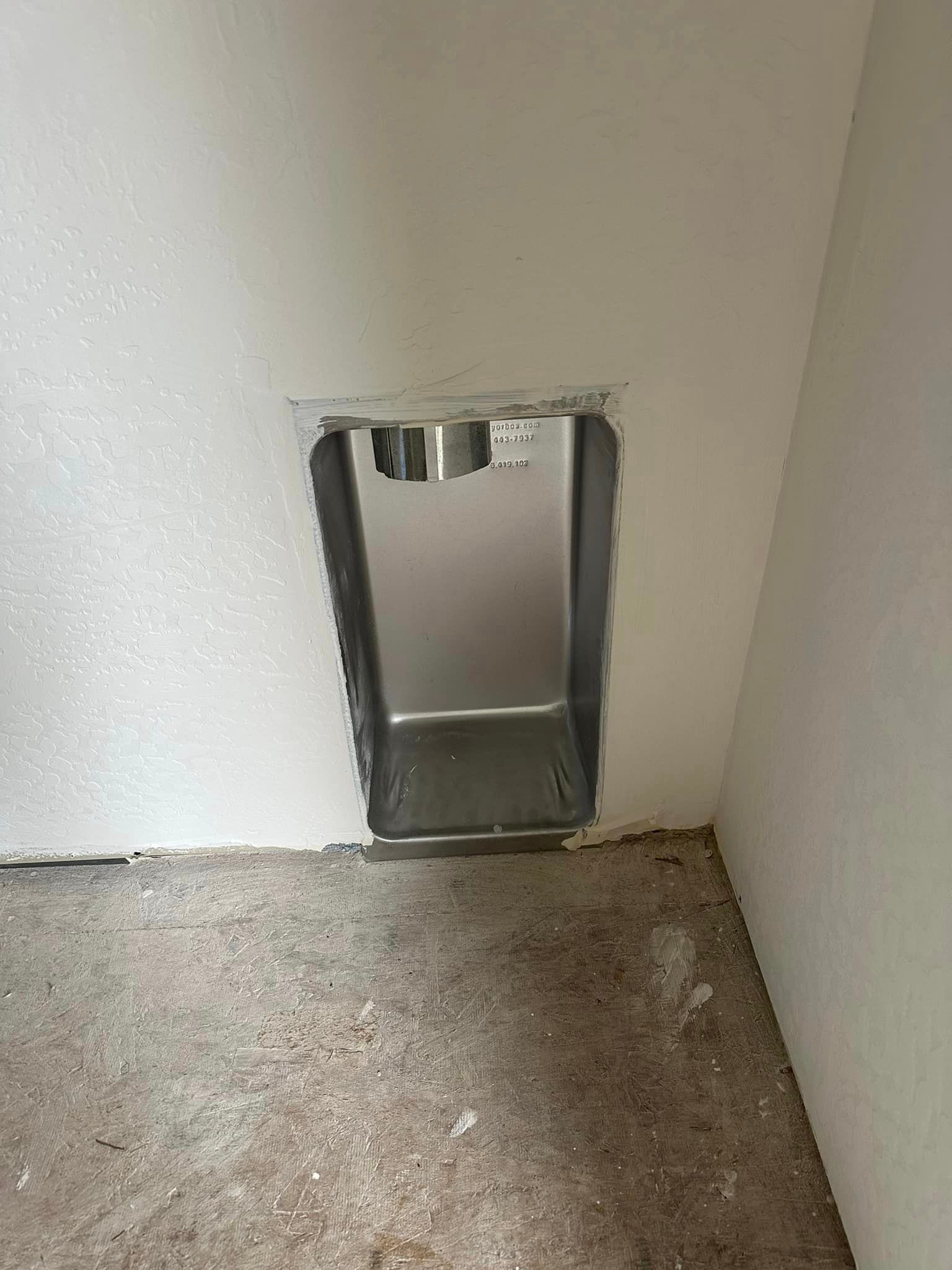 There is a hole in the wall that looks like a dog door.