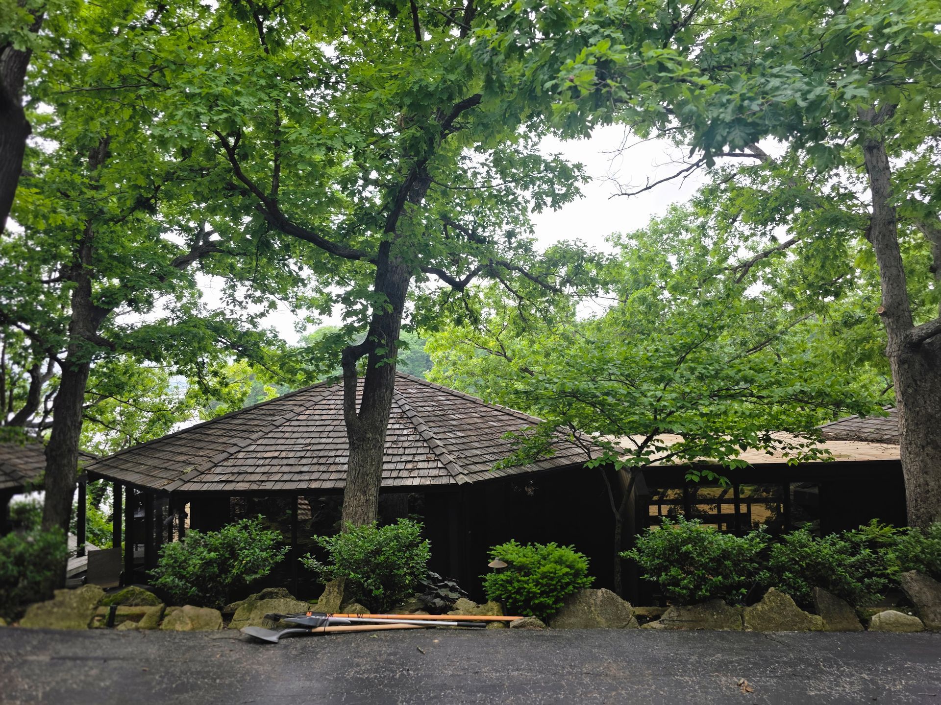 Wooden pavilion among lush trees and shrubs in a park setting
