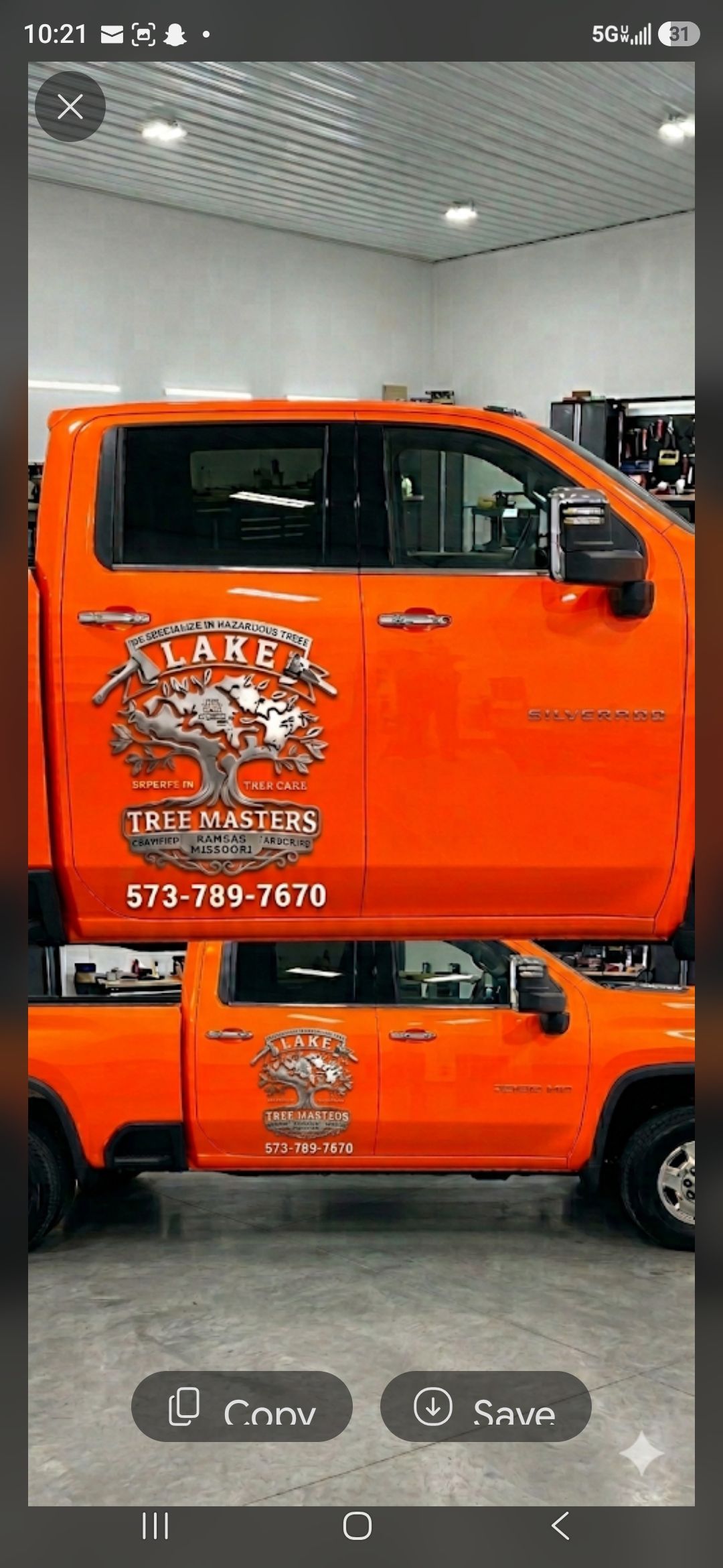 Orange pickup truck with tiger graphic parked inside a garage