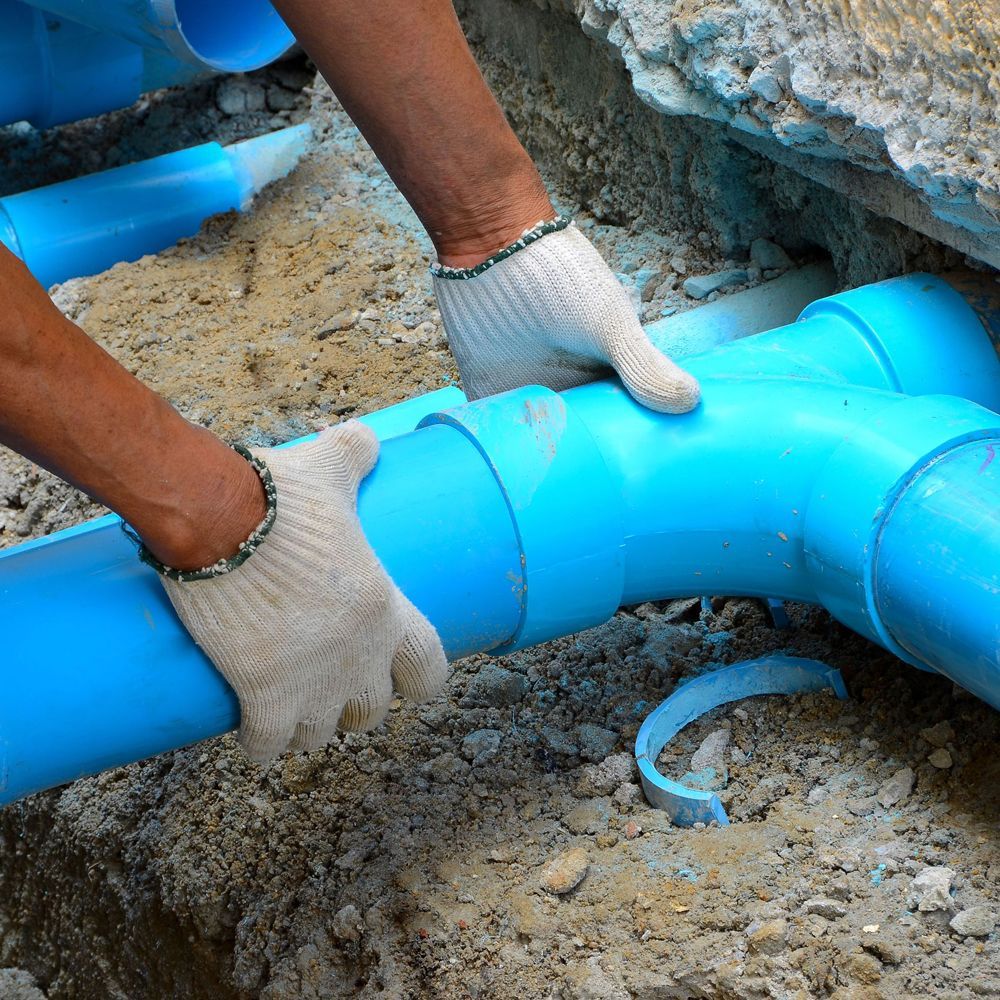 Man repairing a blue pipe