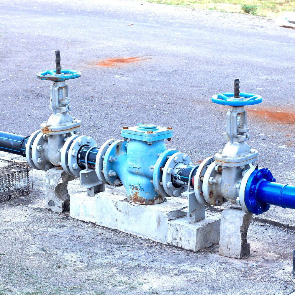 A row of blue pipes with valves attached to them
