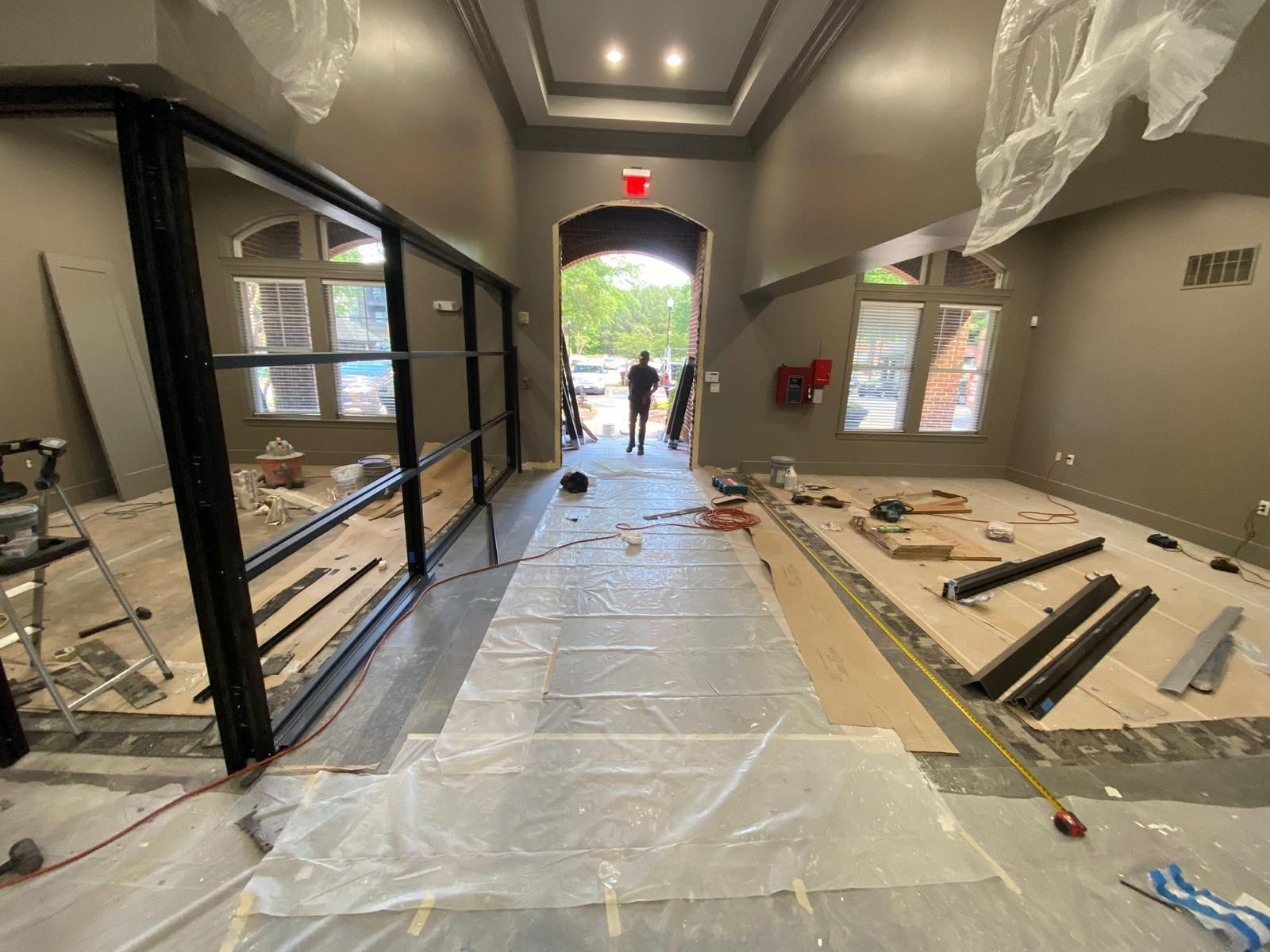 A hallway in a building under construction with a man standing in the background.