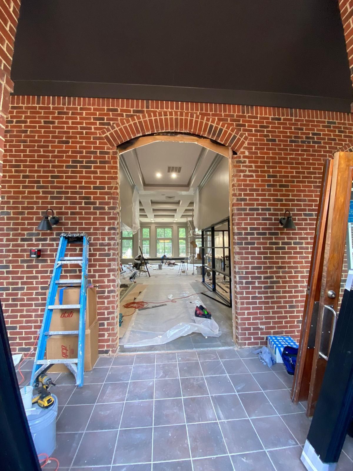 A ladder is sitting in front of a brick wall in a room.