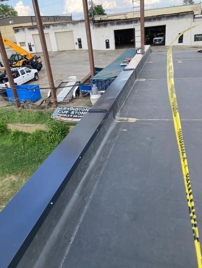 Rooftop walkway with yellow caution tape beside a building and parked equipment below