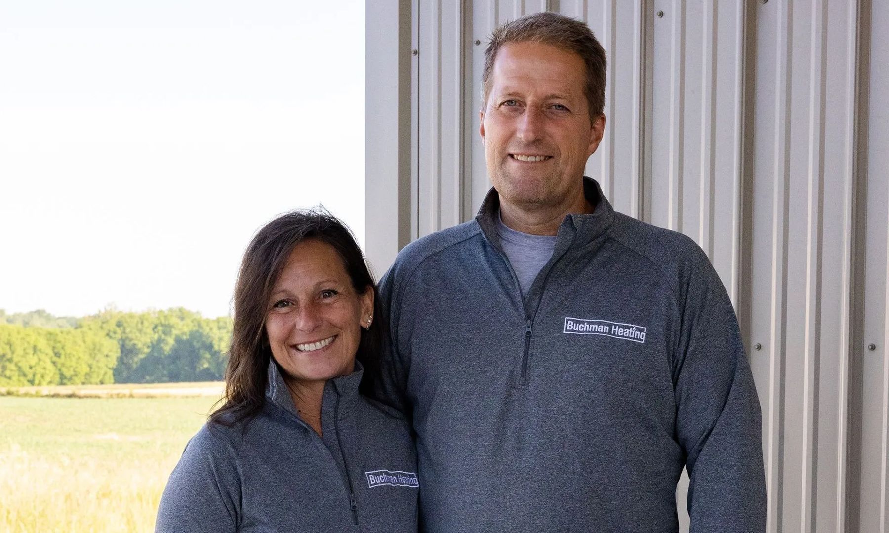 A man and a woman are standing next to each other in front of a building.