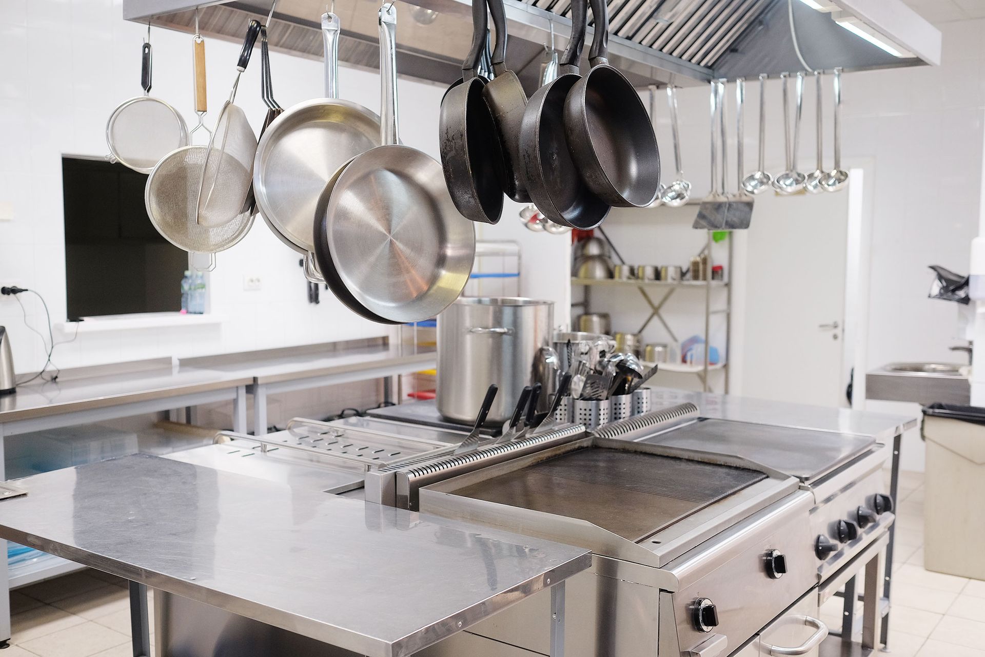 A kitchen with a lot of pots and pans hanging from the ceiling.