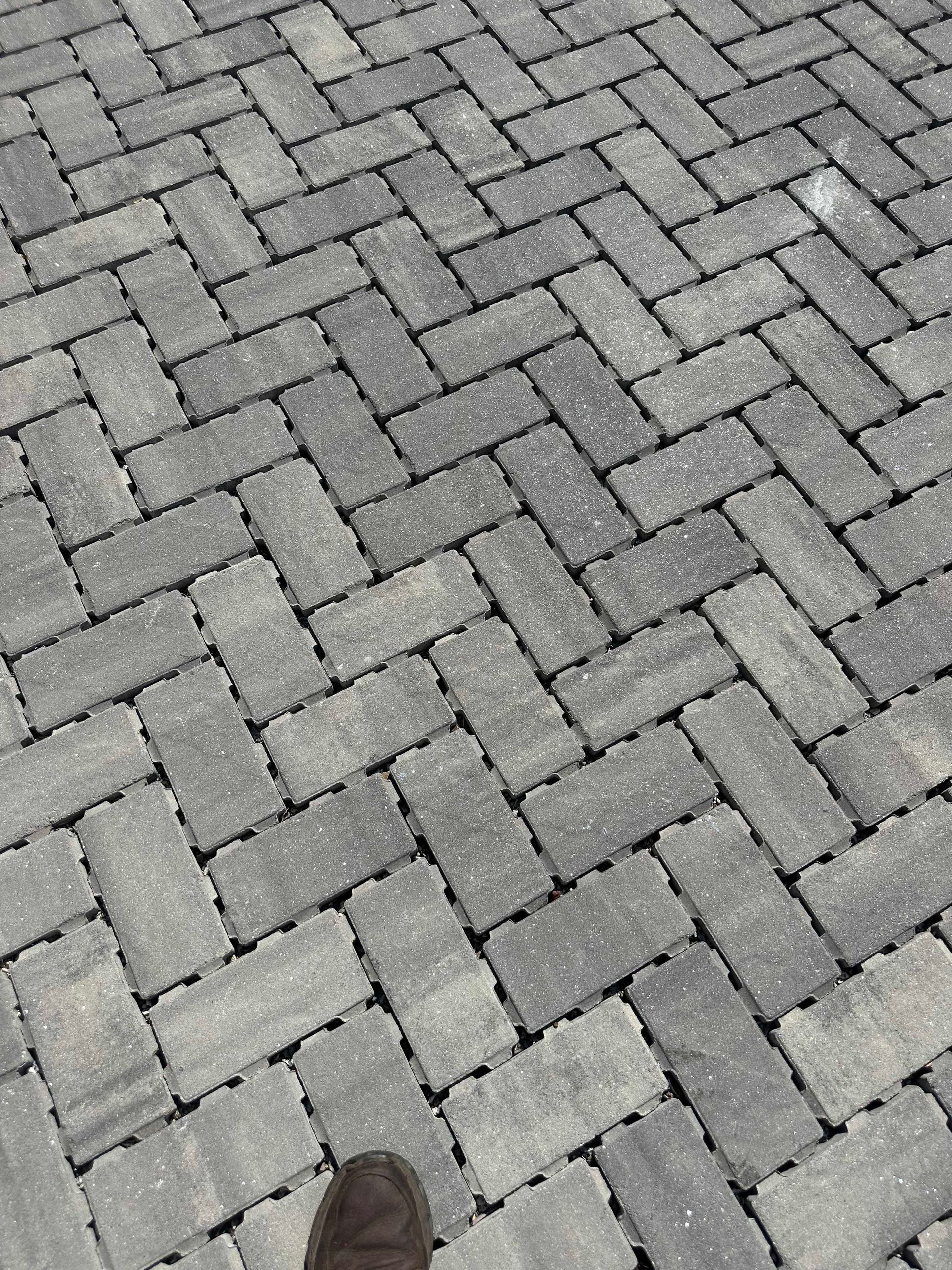 Herringbone pattern paving stones in shades of gray.