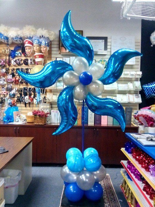 A blue and white flower made of balloons in a store