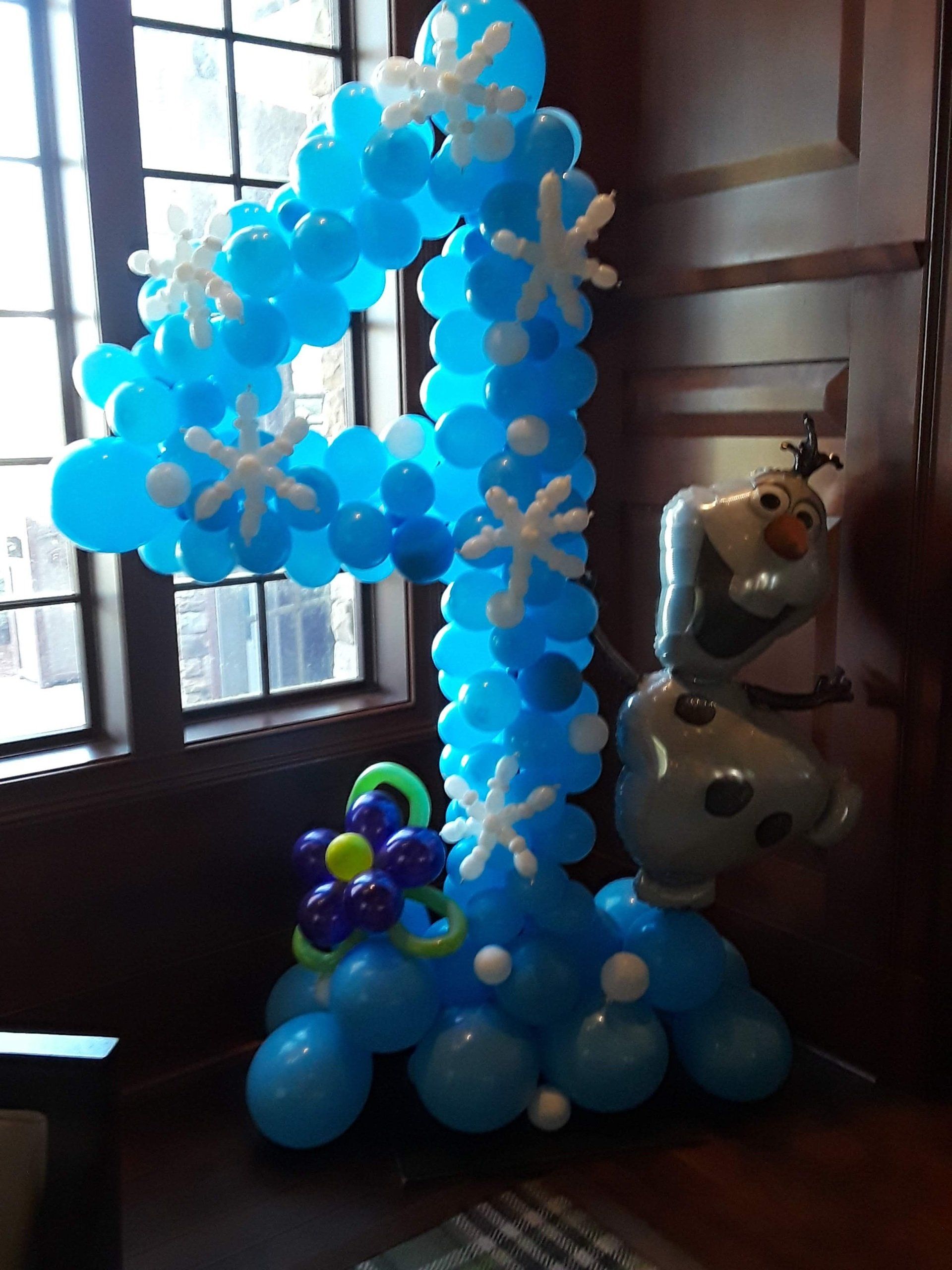 A number 1 made of blue balloons and snowflakes