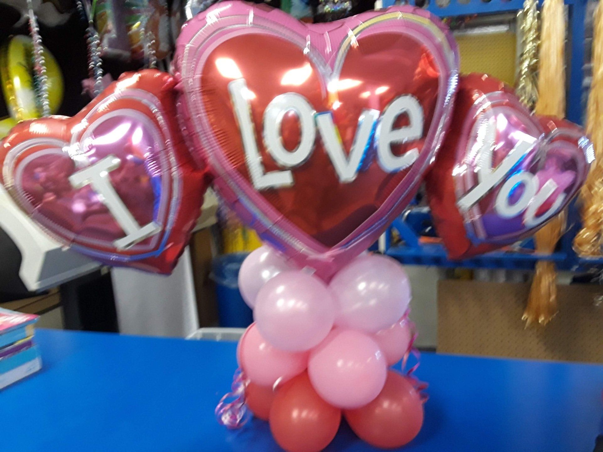 A bunch of heart shaped balloons that say i love you