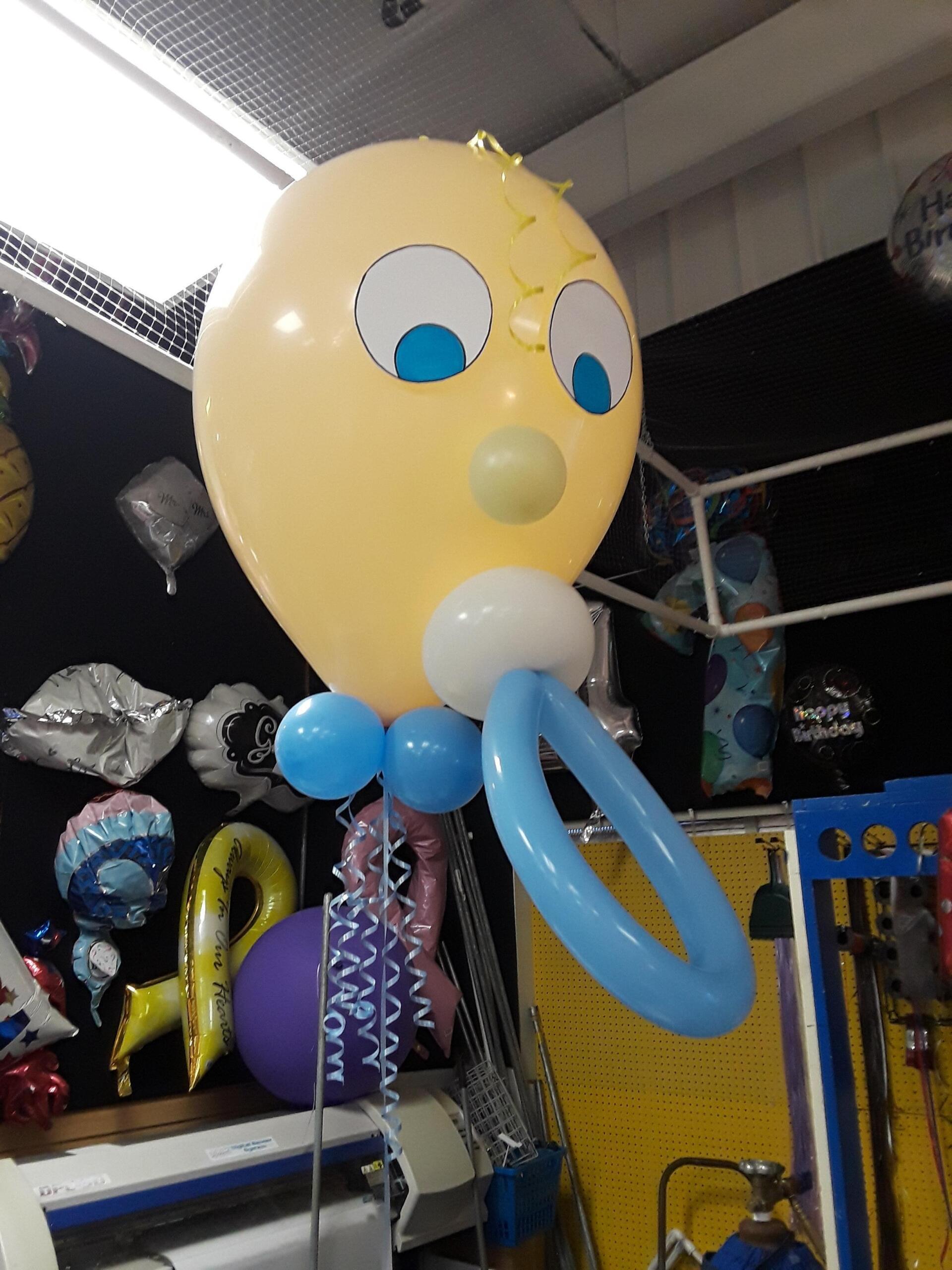 A baby balloon with a pacifier attached to it