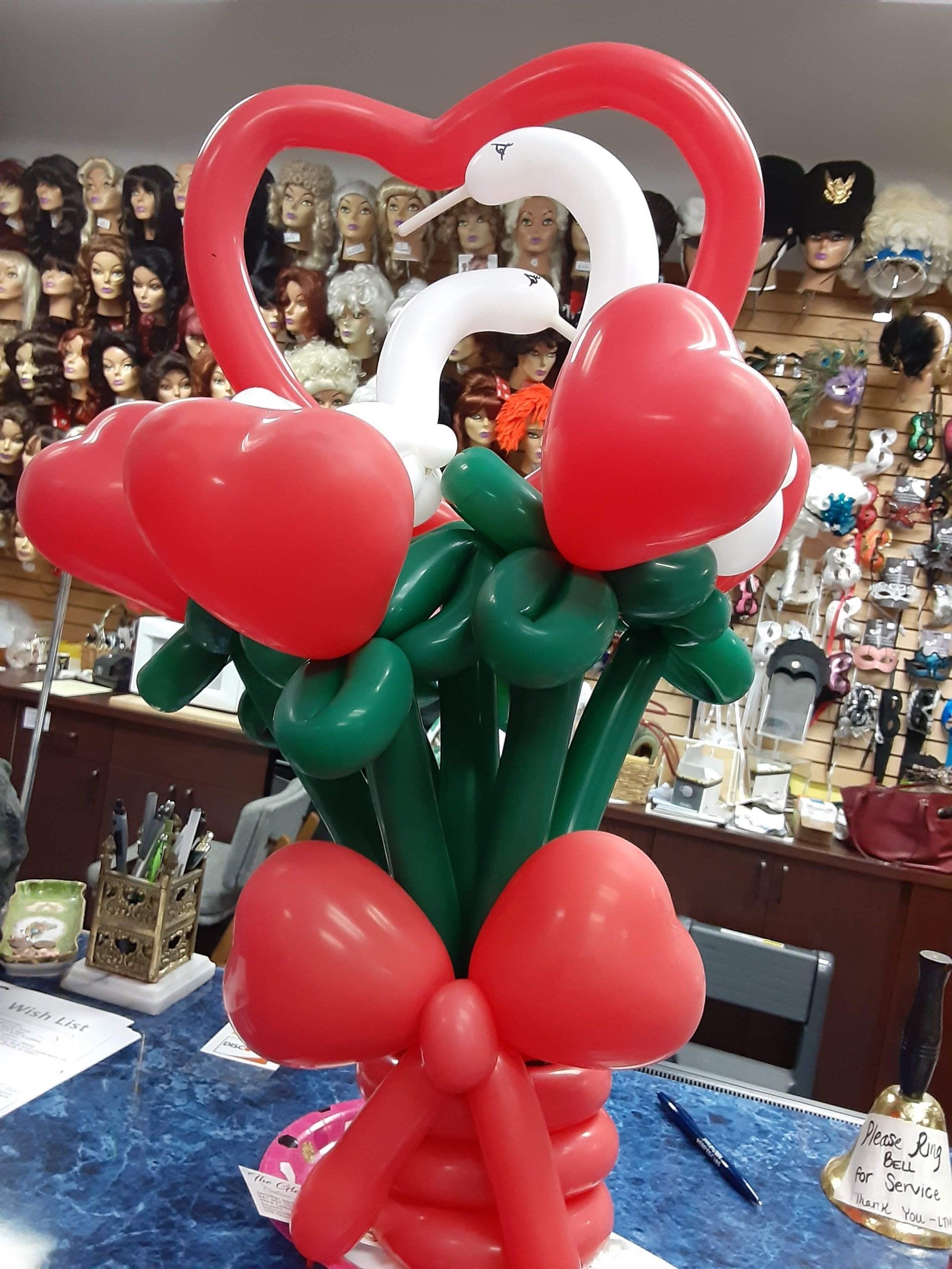 A bunch of red and green balloons in the shape of hearts