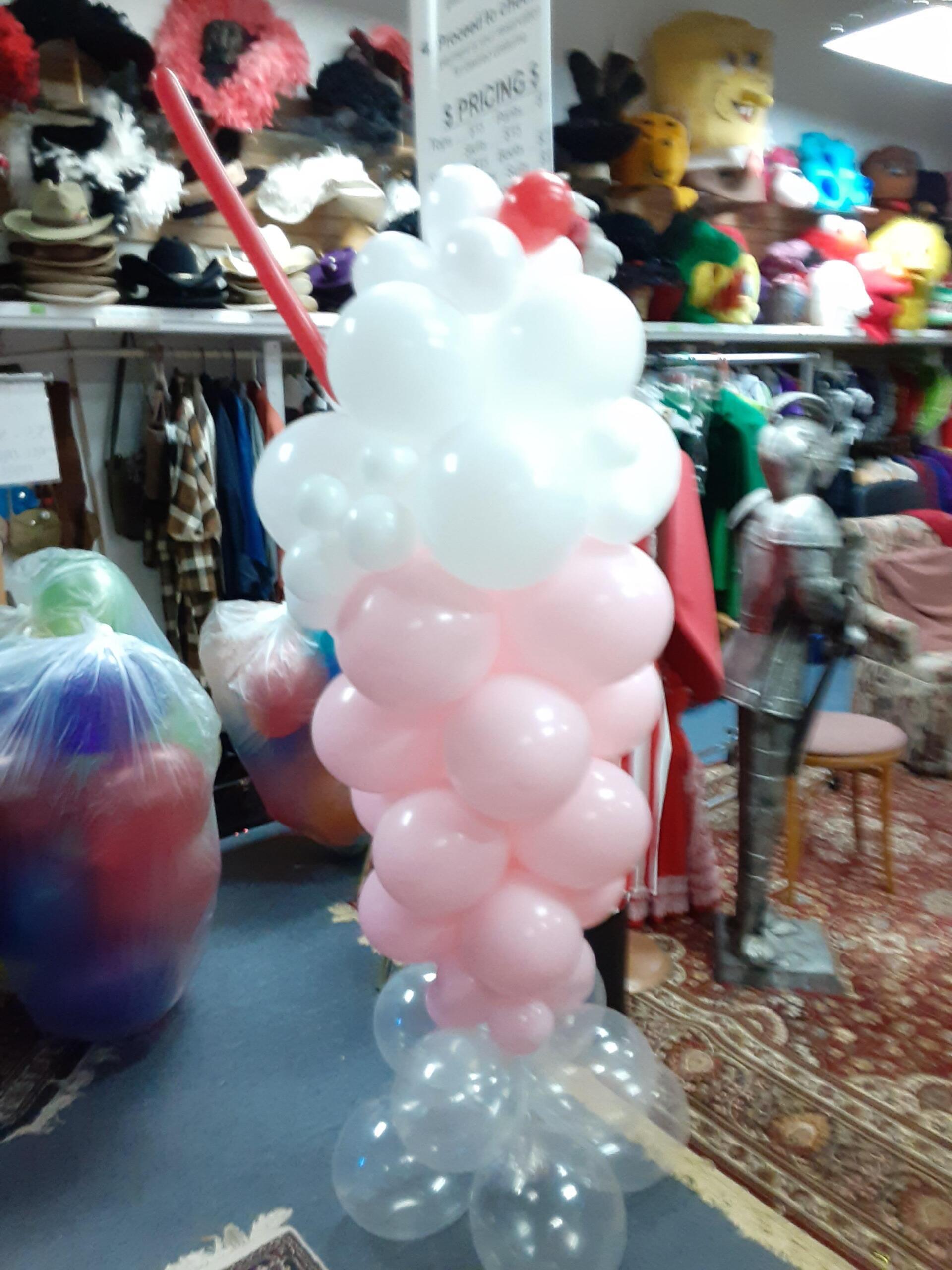A pink and white balloon shaped like a milkshake