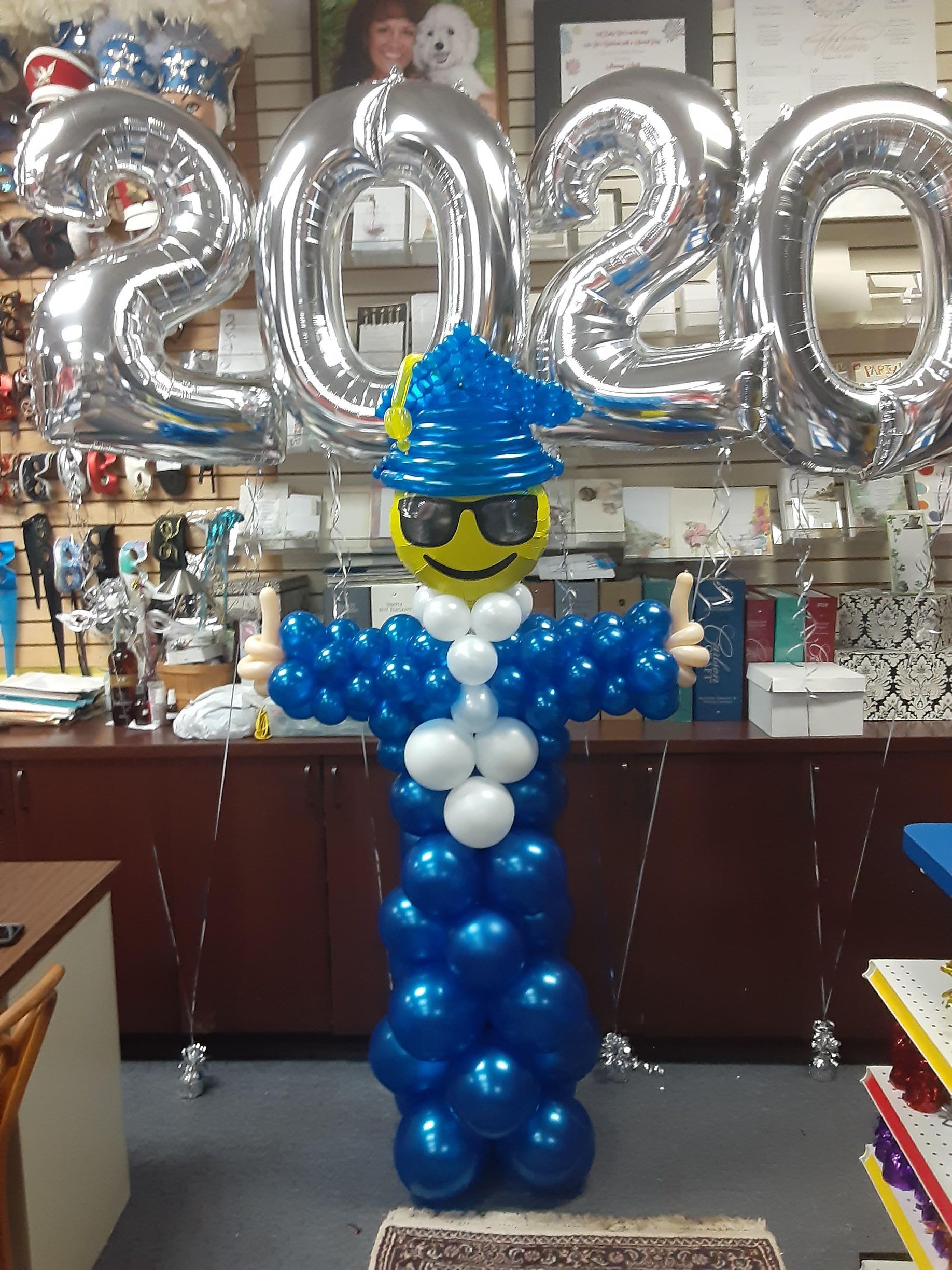 A clown made out of blue and white balloons giving a thumbs up