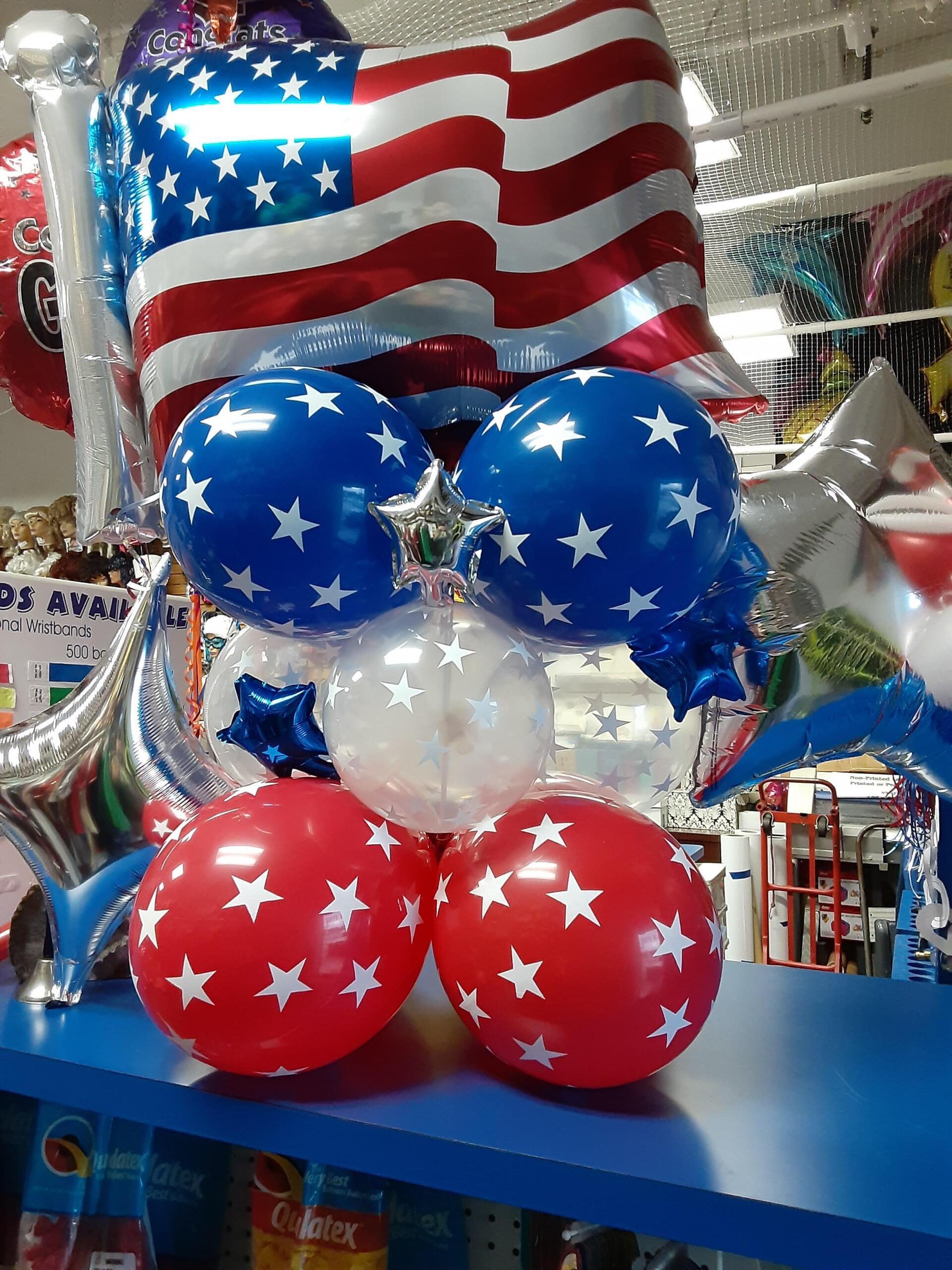 A bunch of red white and blue balloons on a table