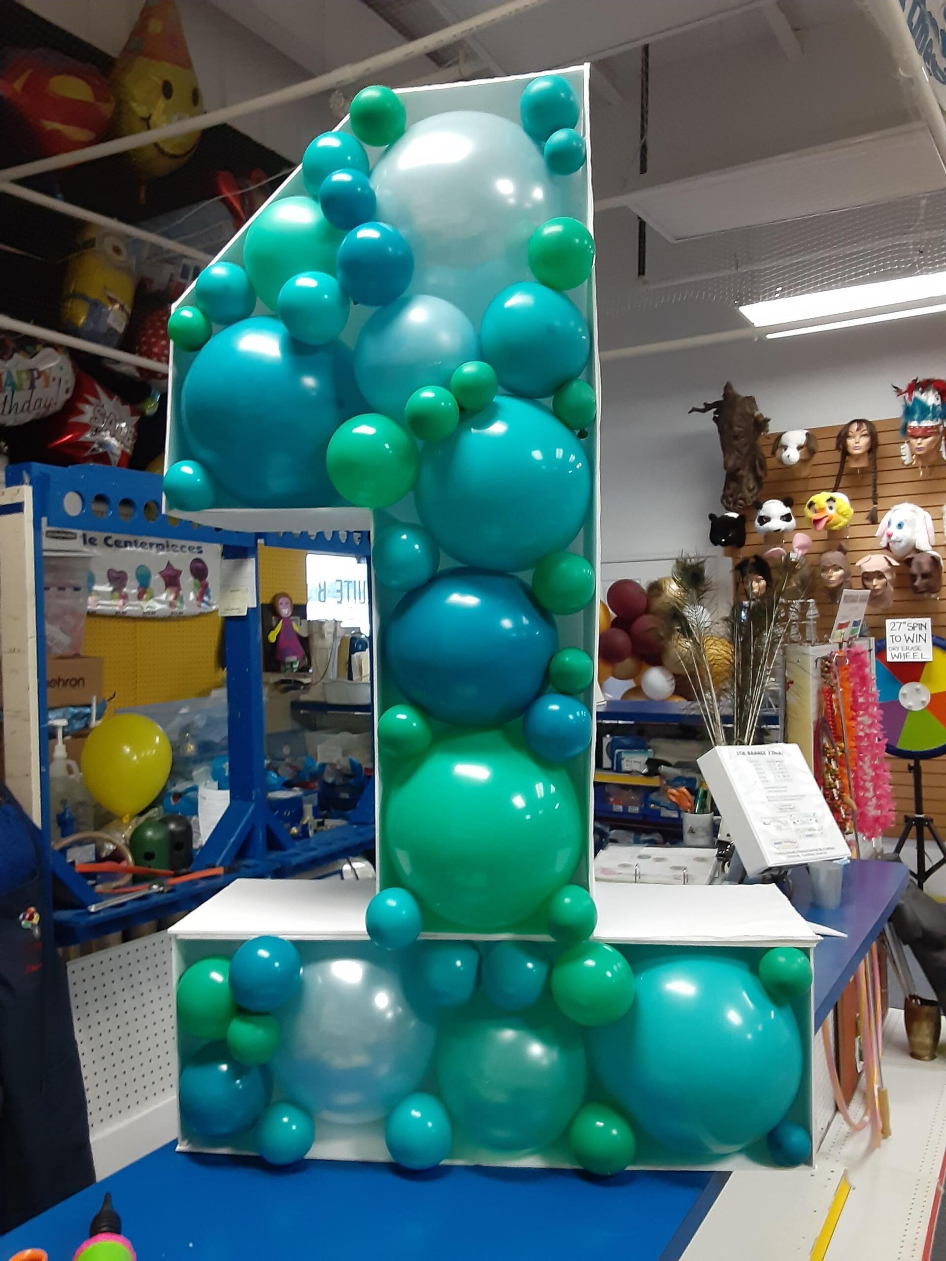 A number 1 made out of blue and green balloons
