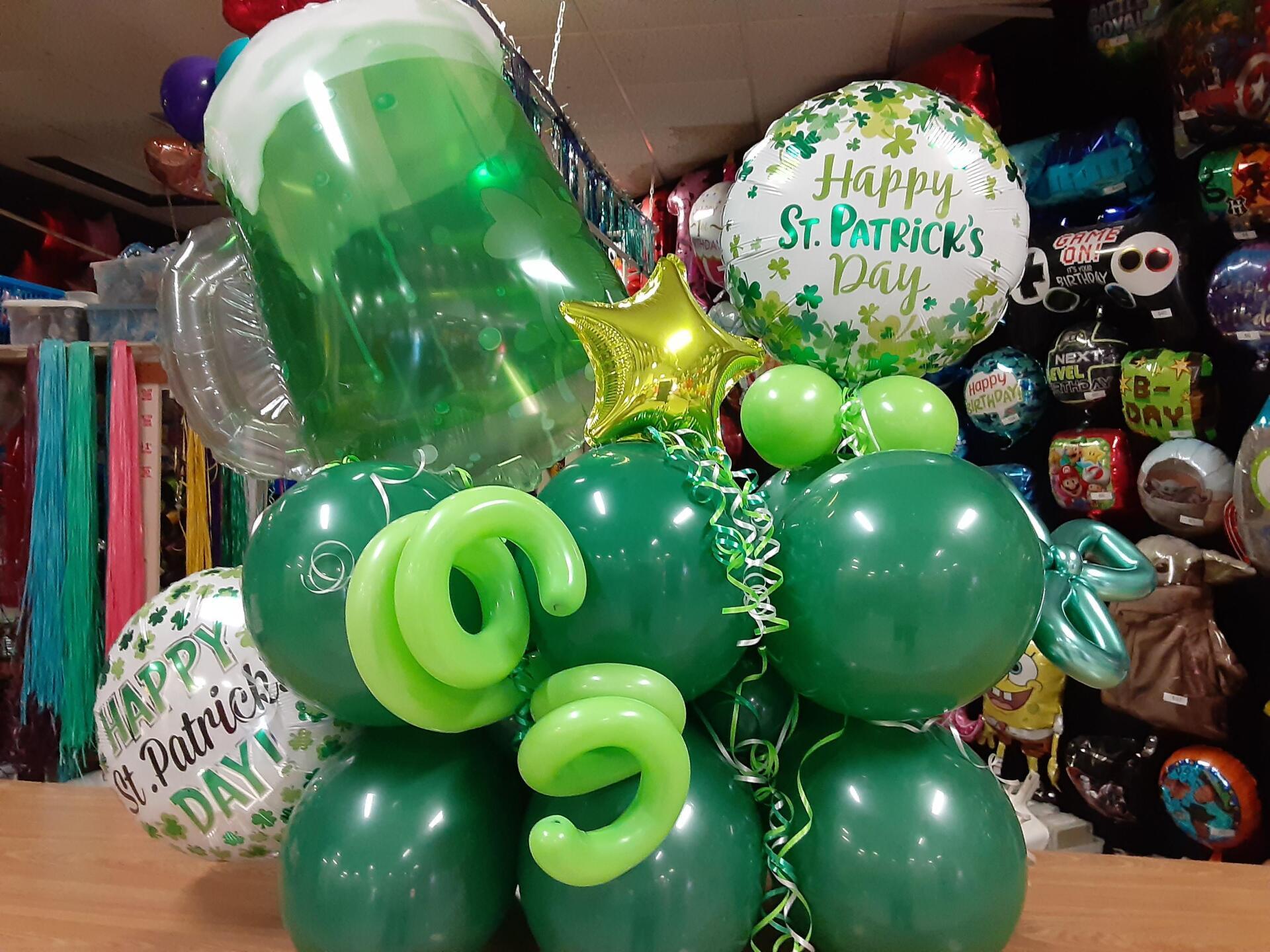 A bunch of green balloons are sitting on a table.