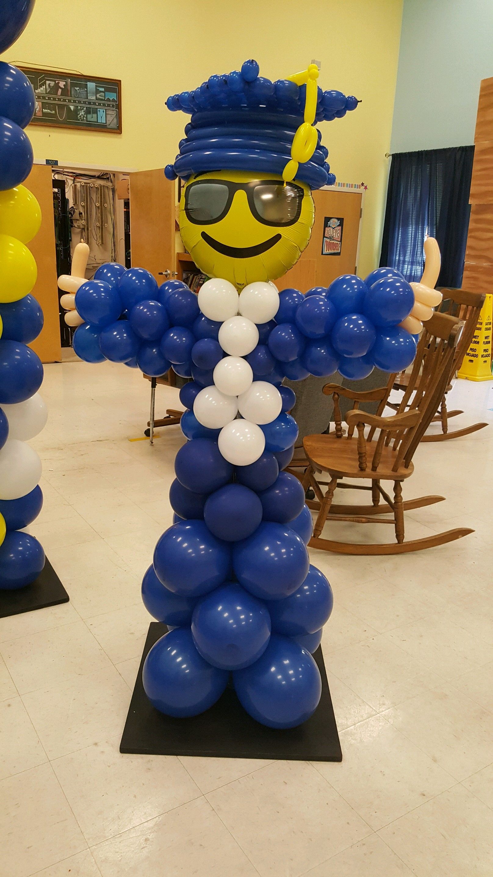 A balloon sculpture of a man wearing a graduation cap and gown.