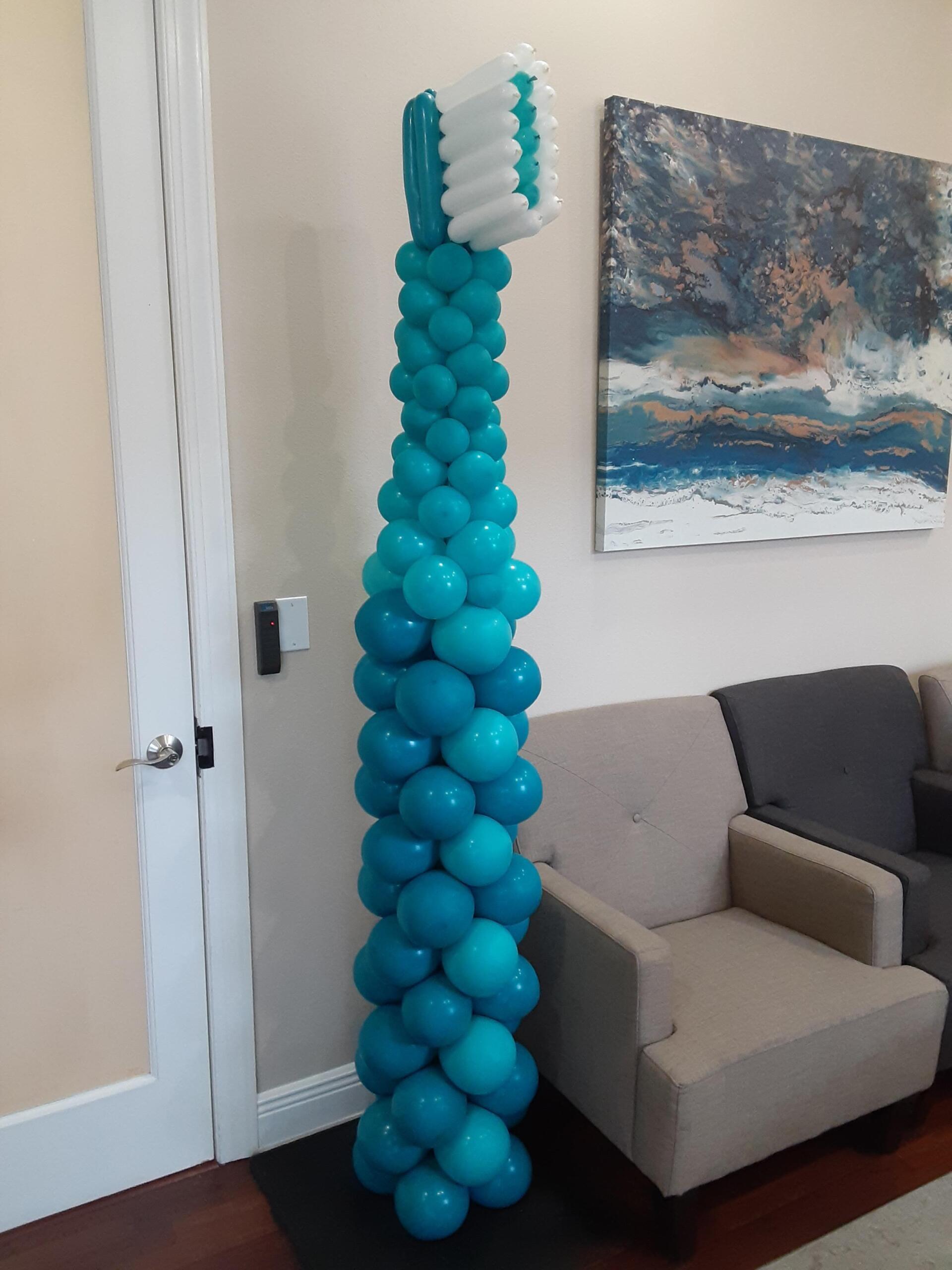 A toothbrush made out of blue balloons in a living room