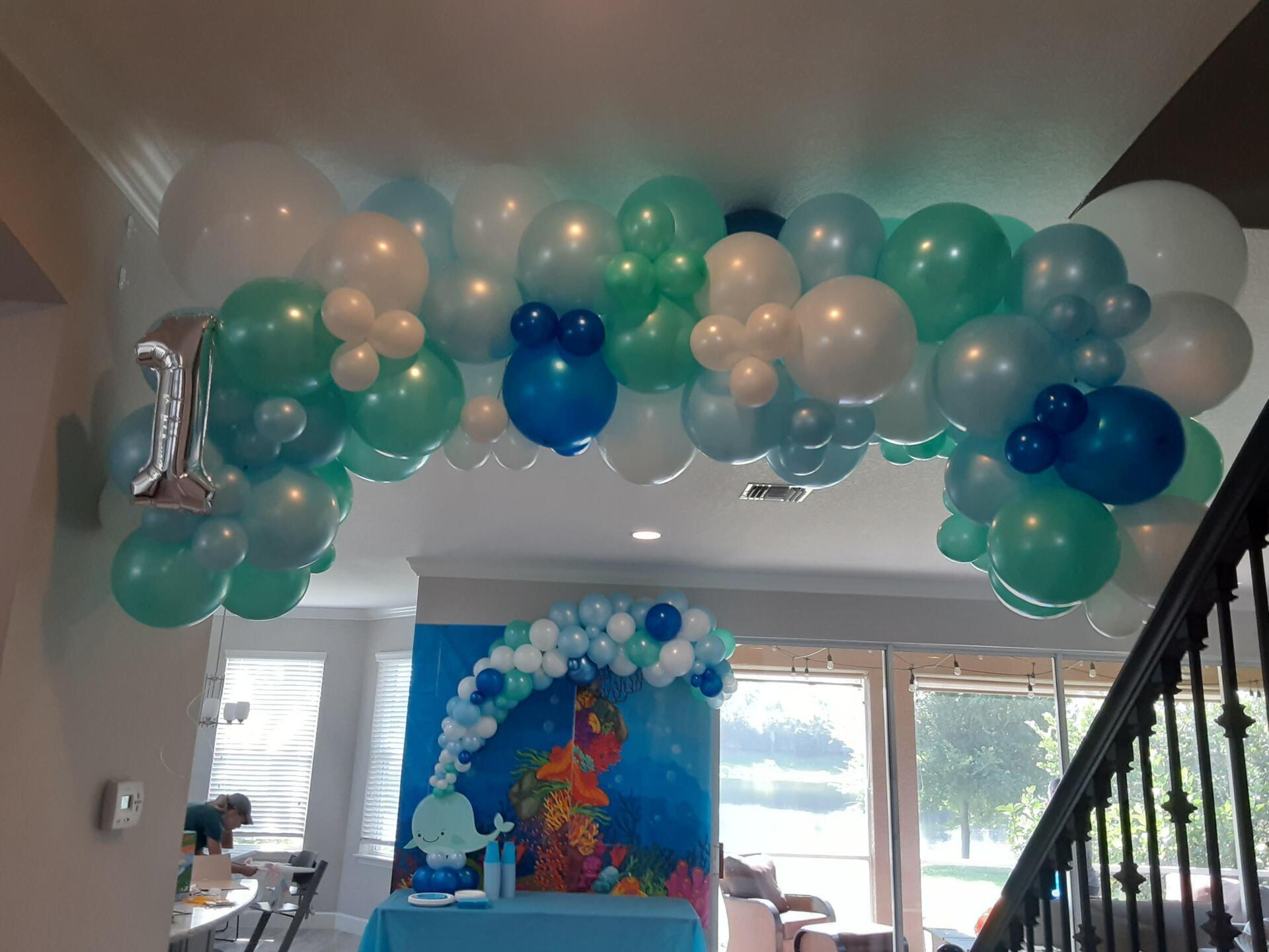 A bunch of balloons are hanging from the ceiling of a room.