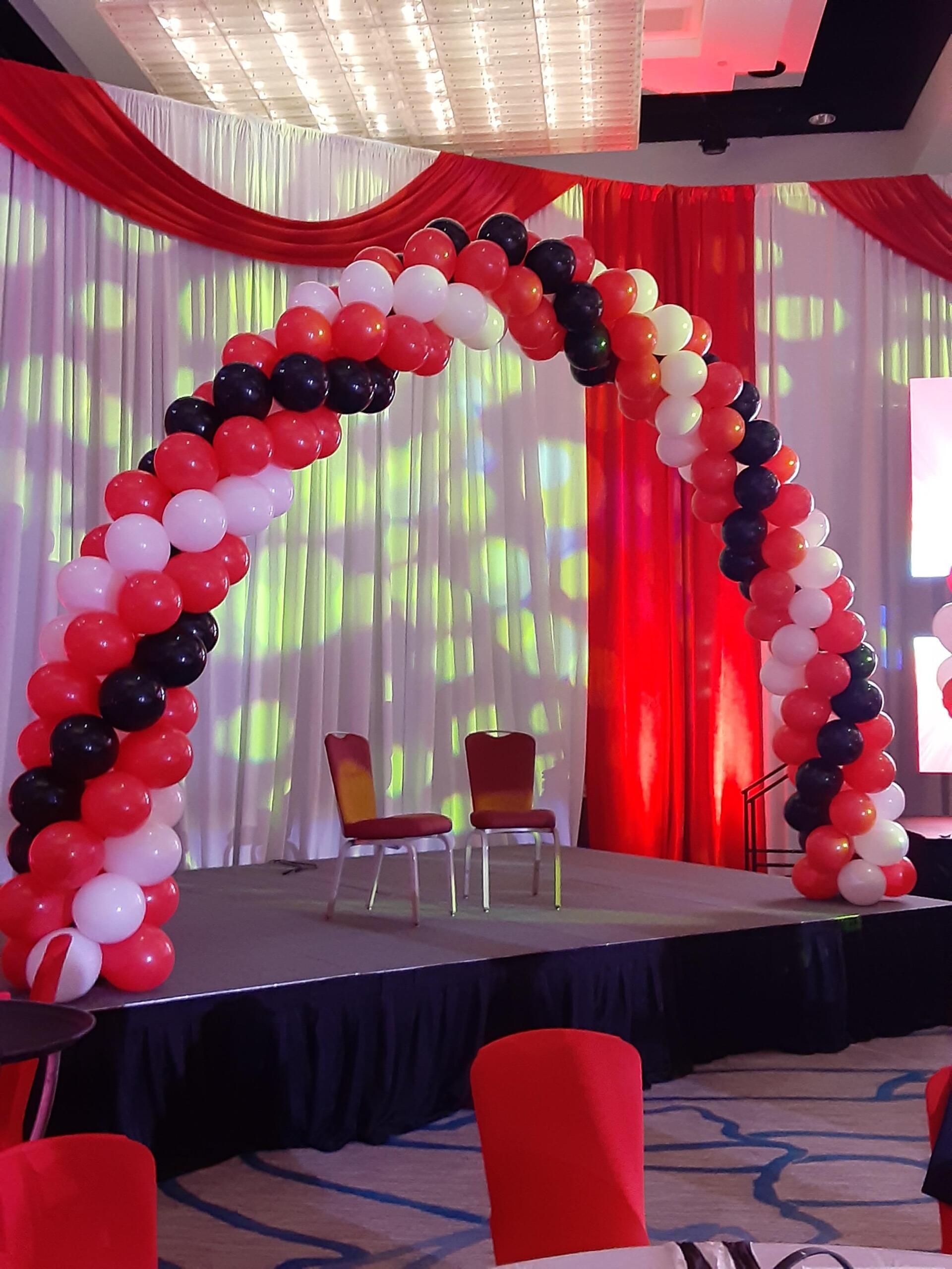 A stage decorated with red white and black balloons