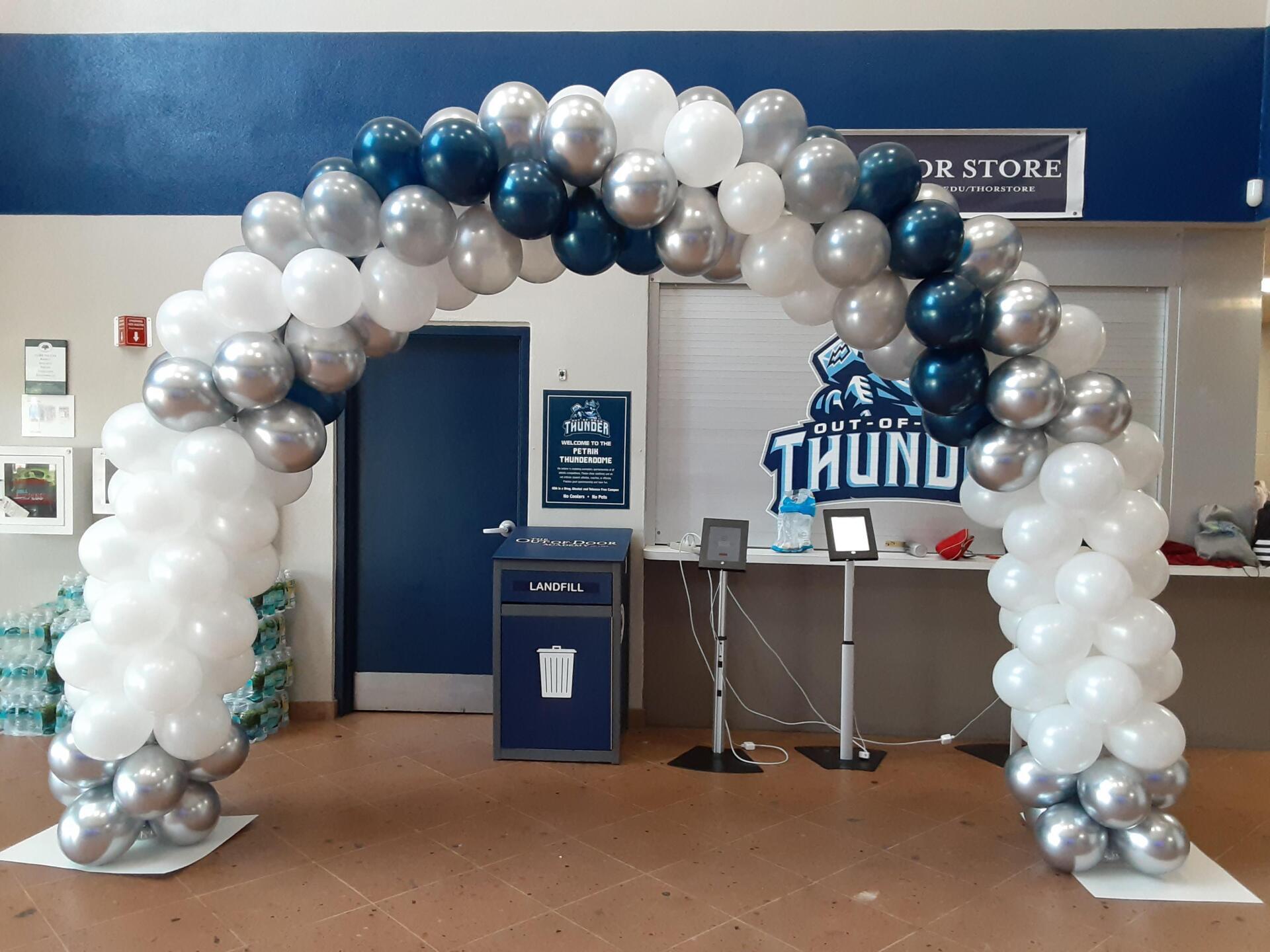 A blue and white balloon arch with the word thund on it