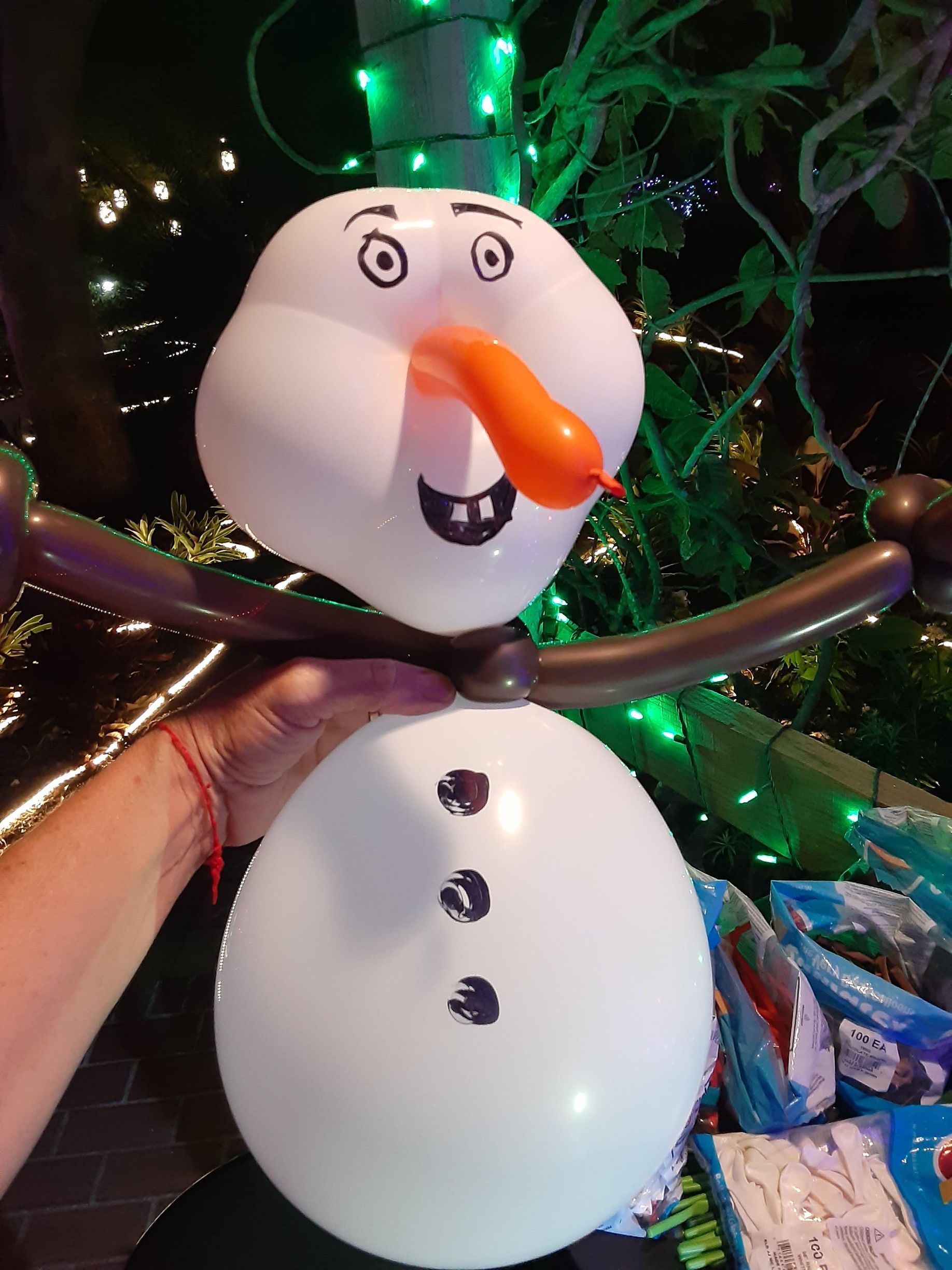 A person is holding a snowman made out of balloons.