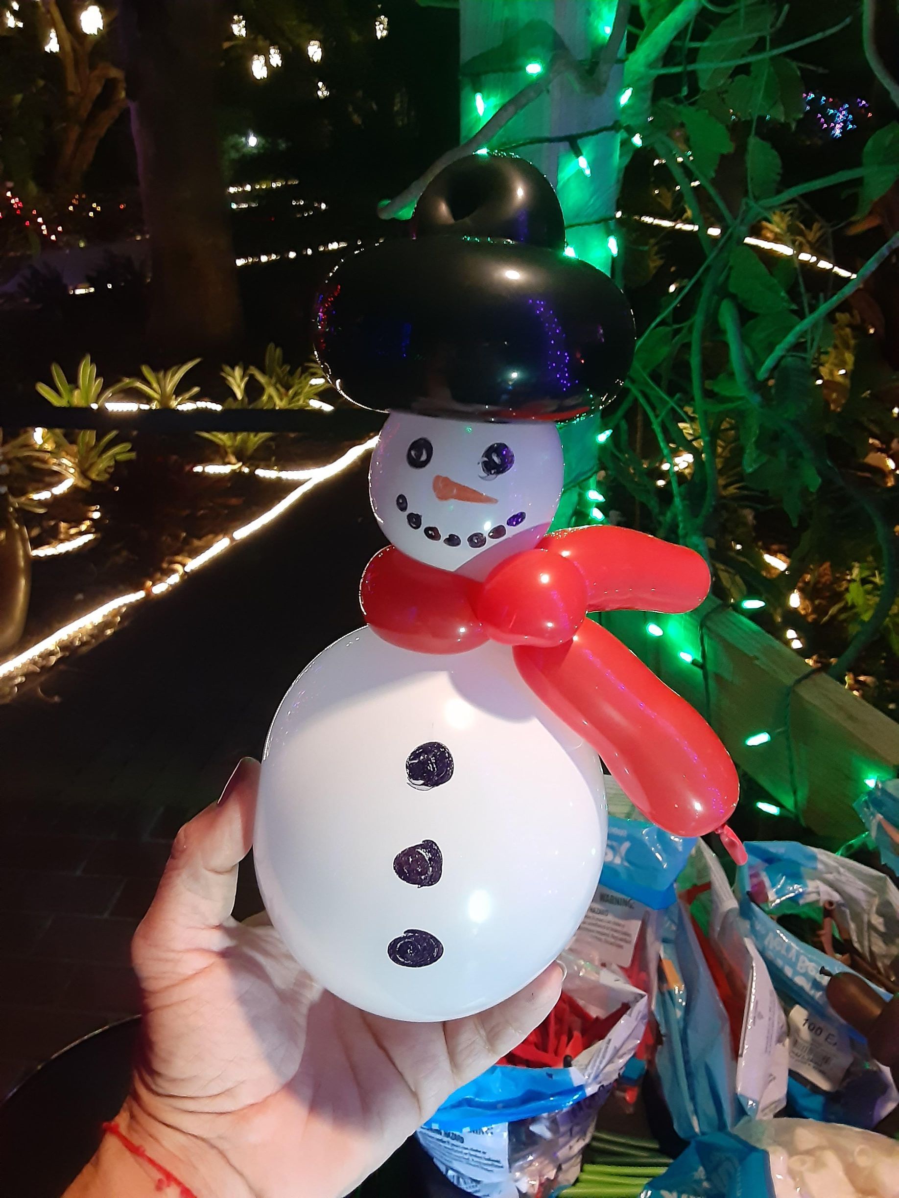 A person is holding a snowman made out of balloons