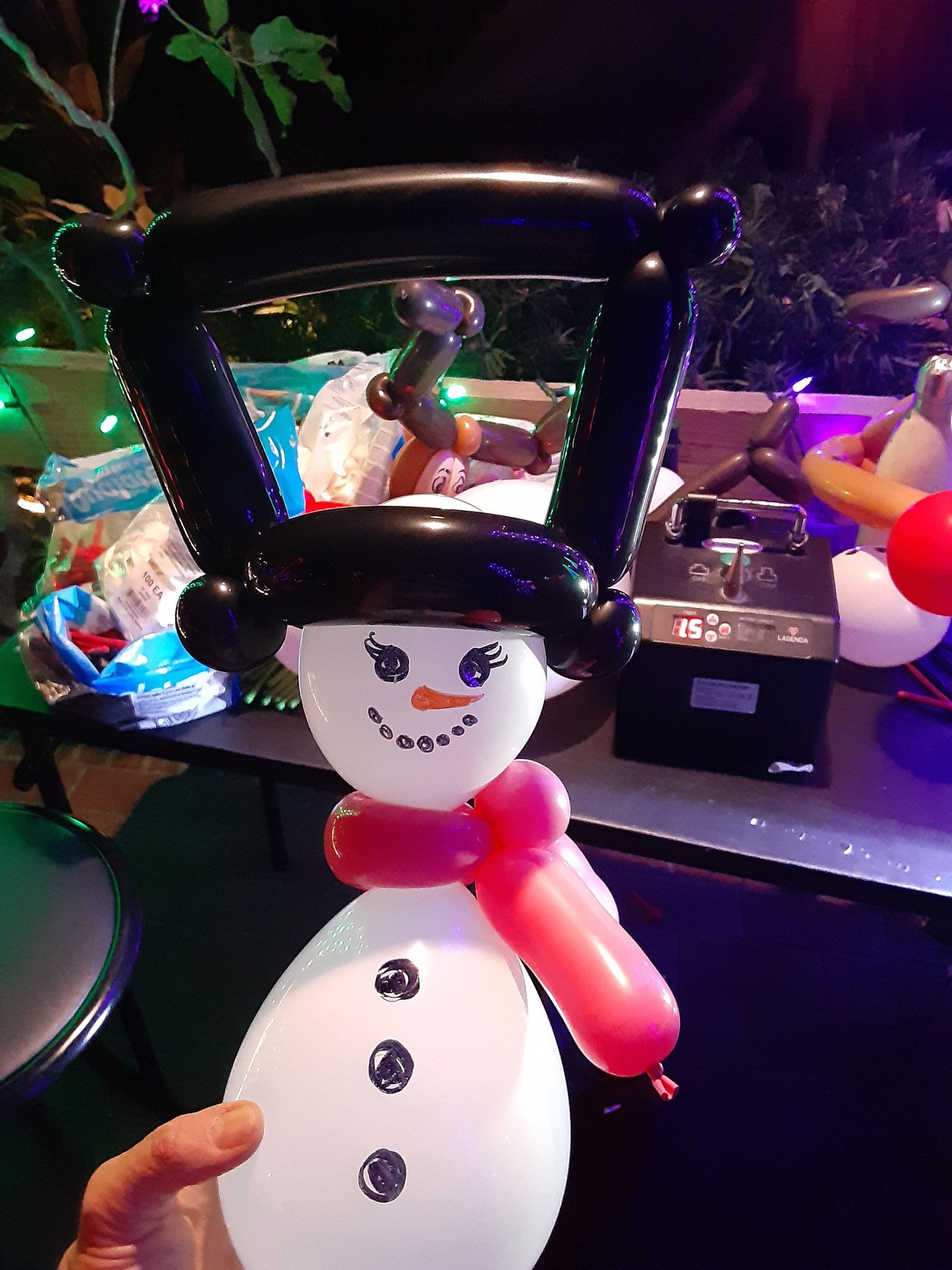 A person is holding a snowman made out of balloons.