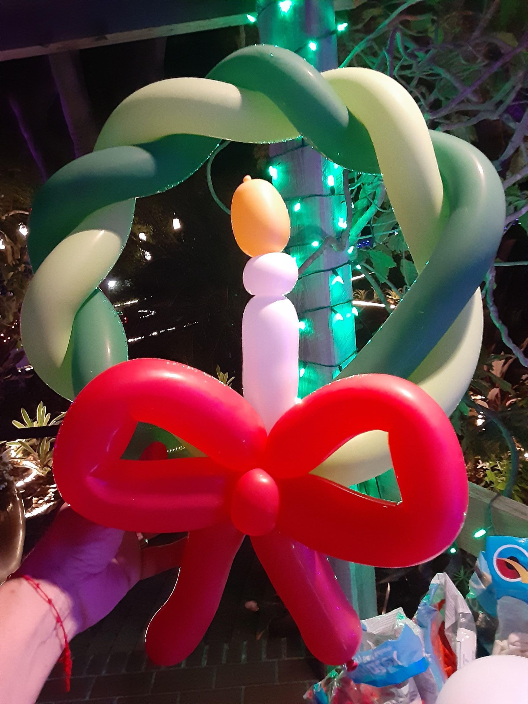 A wreath made out of balloons with a candle in the middle