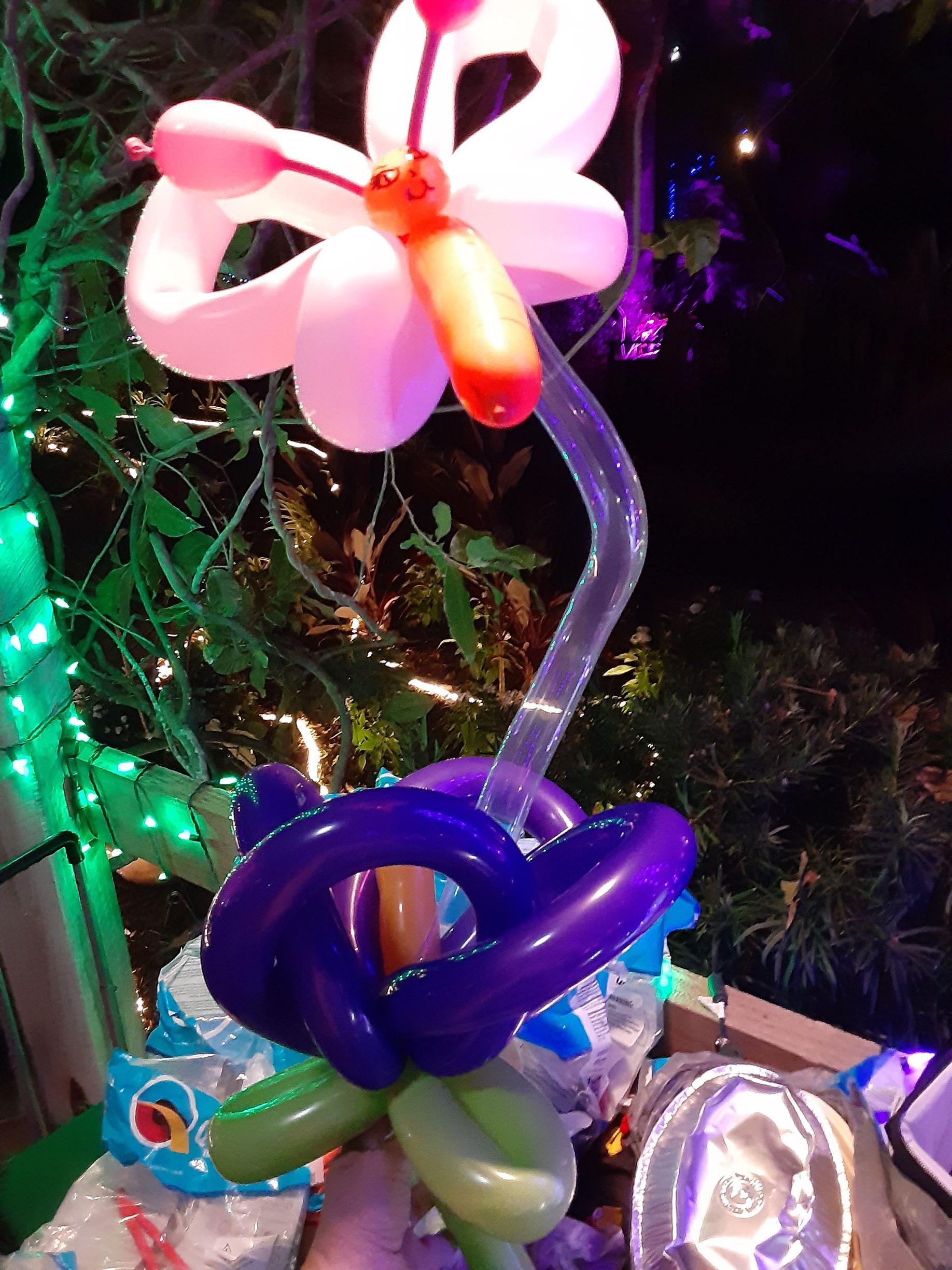 A flower made out of balloons is sitting on a table.