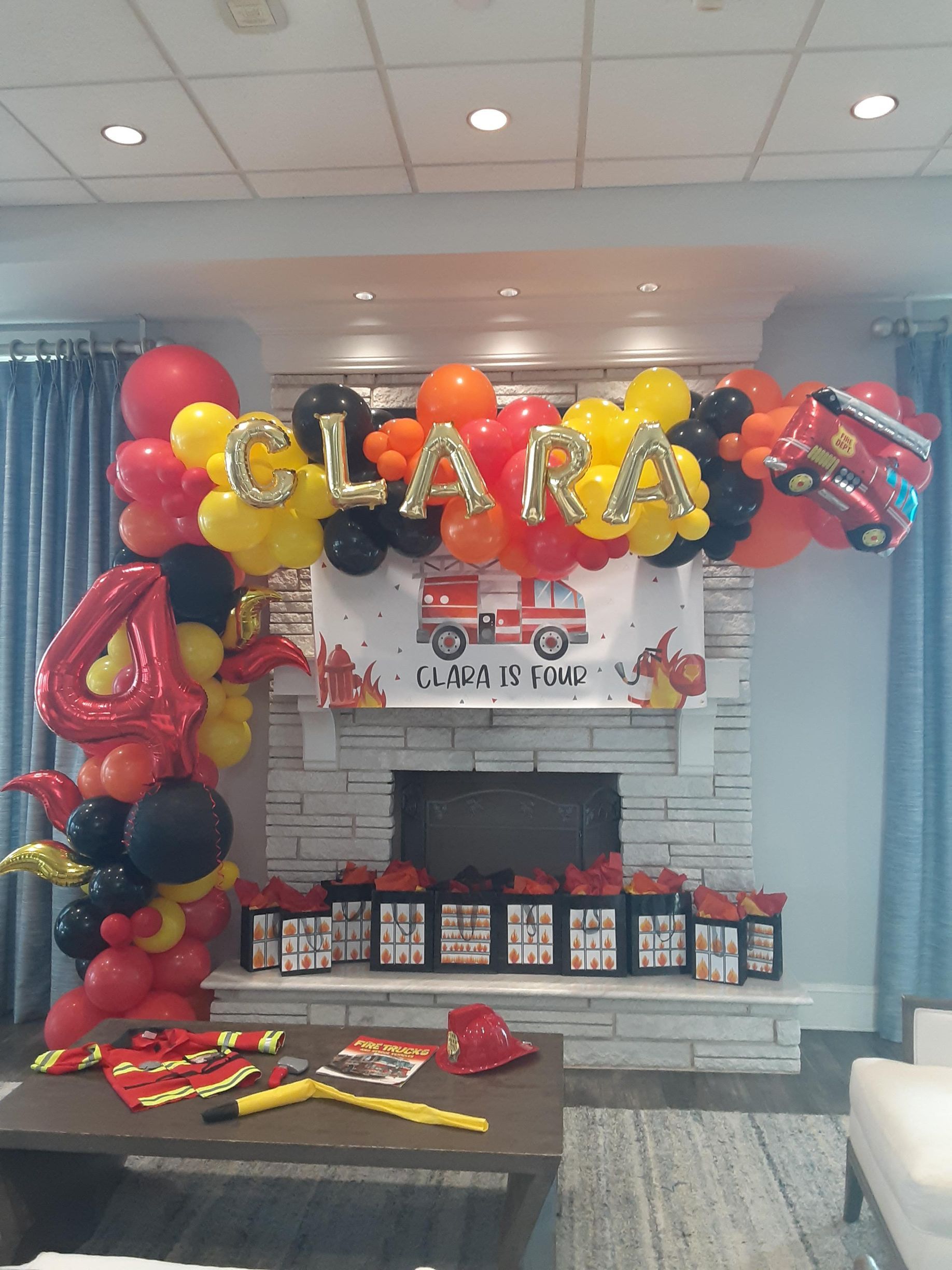 A fireplace decorated with balloons and a sign that says clara