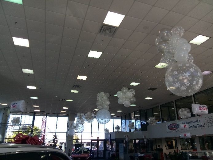 Dealership interior with clear balloons, some with decorations, hanging from the ceiling.