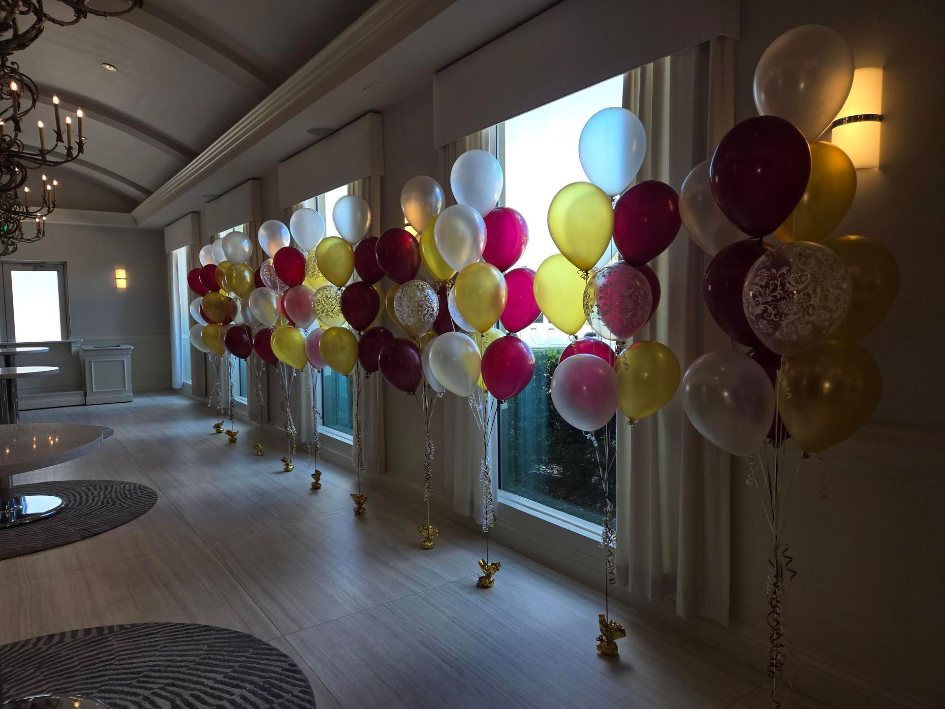 Balloons in various colors decorate a room with large windows