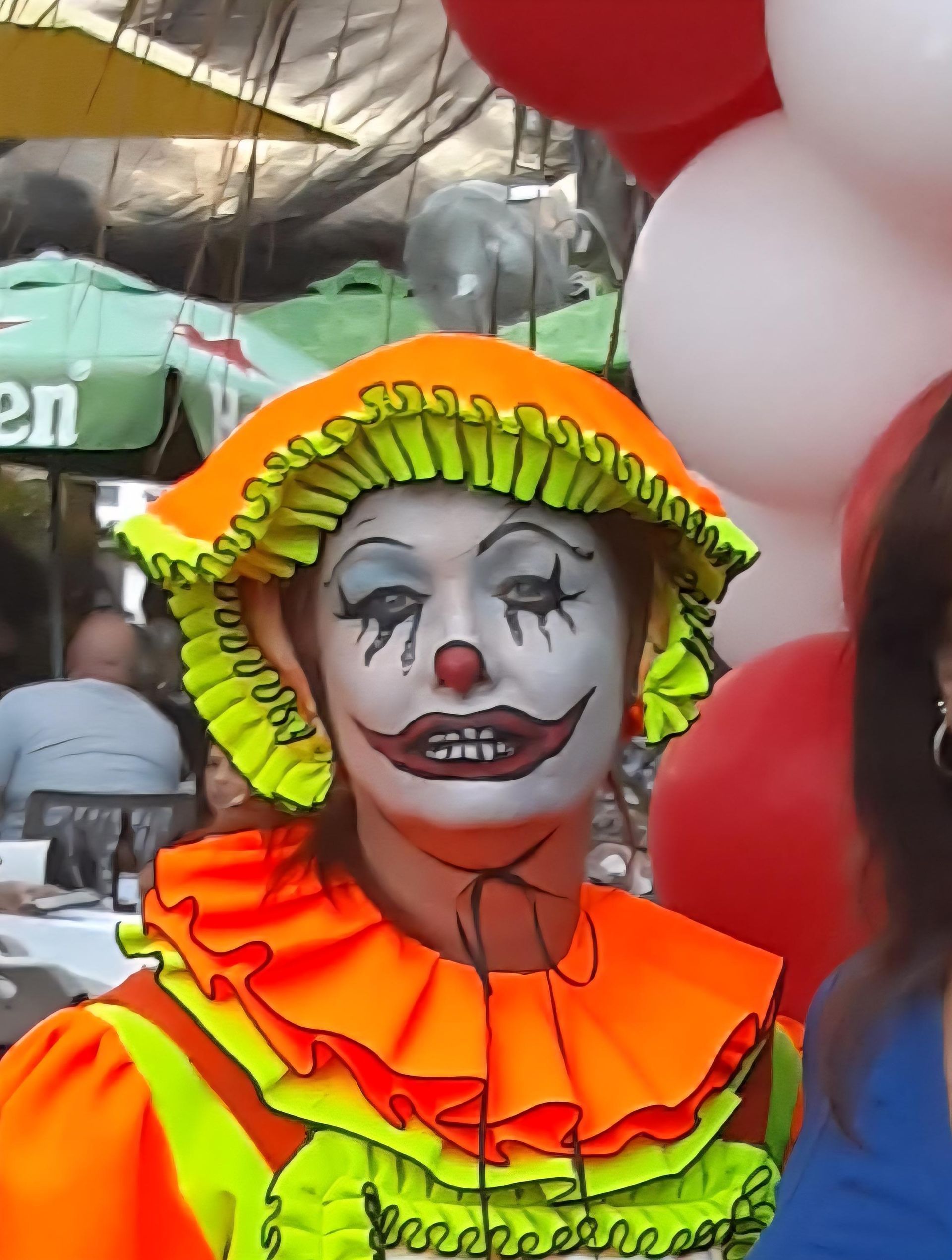 Woman in clown makeup and costume, orange and yellow