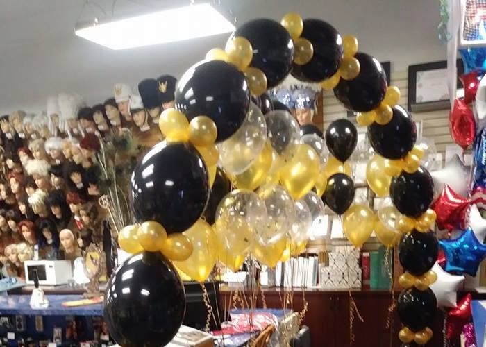 A bunch of black and gold balloons in a store