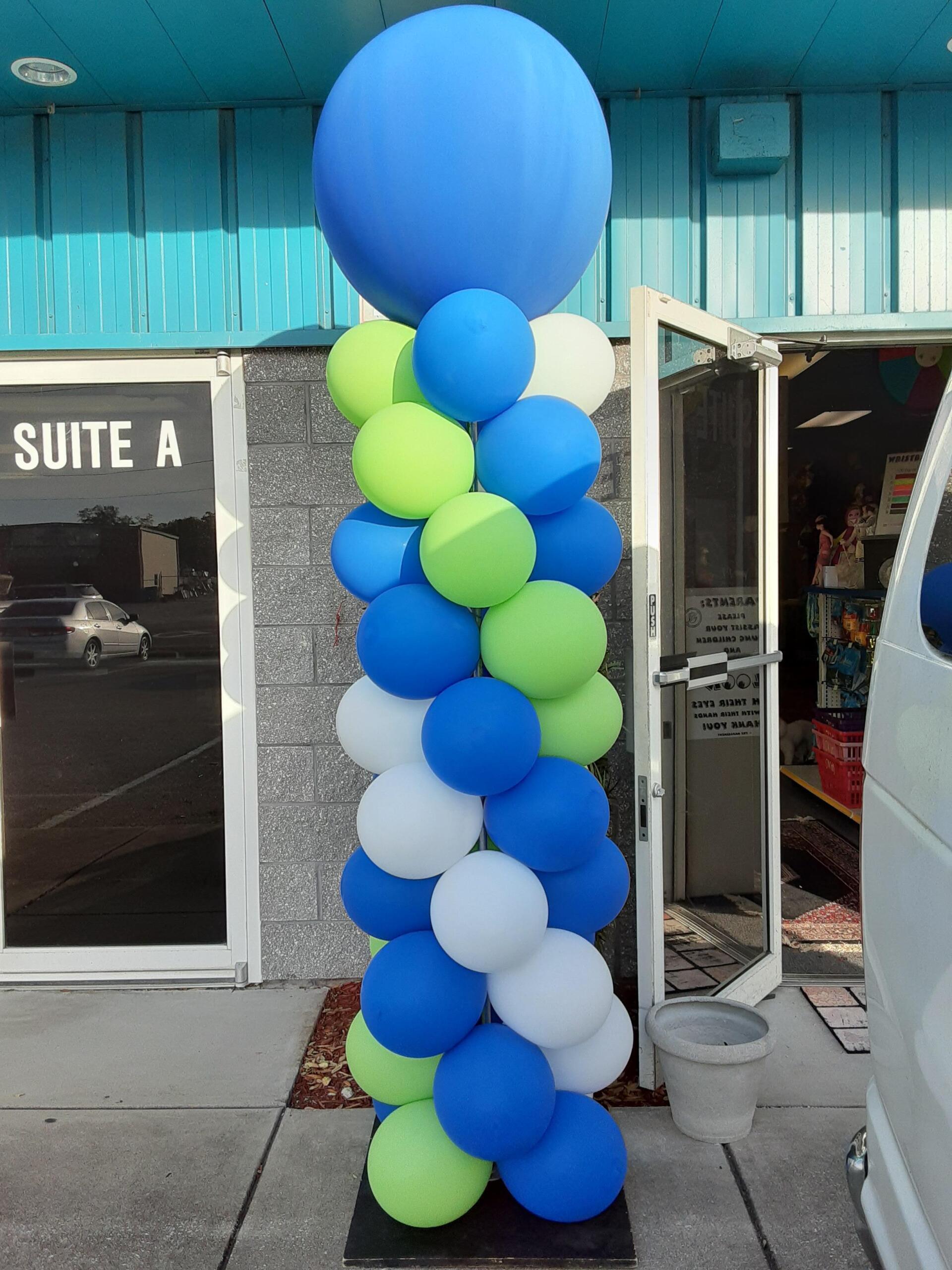 Blue and green balloons are stacked on top of each other in front of suite a