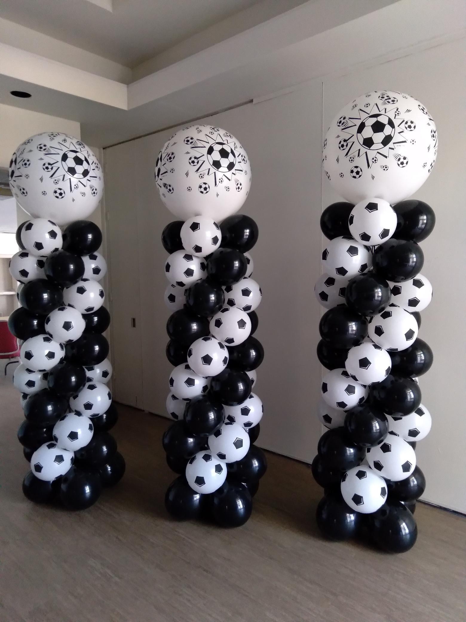 Three columns made of black and white balloons with soccer balls on them