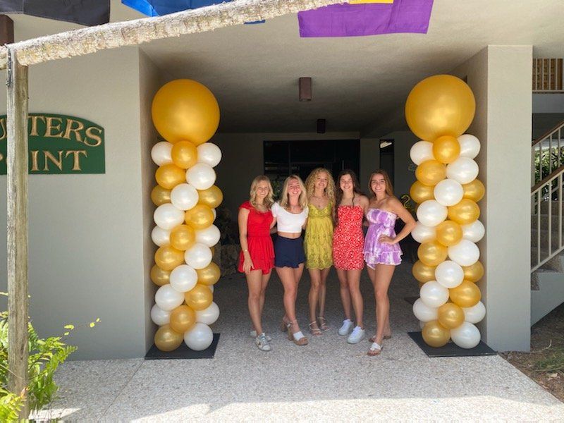 A group of women standing in front of a building that says oyster point