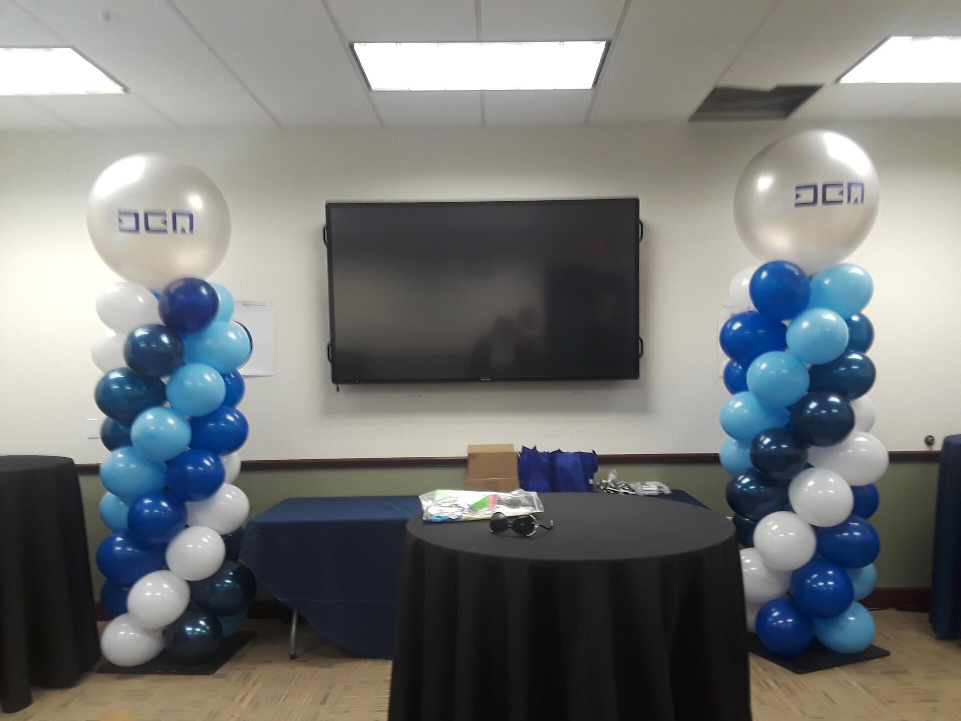 Two columns of blue and white balloons in a room