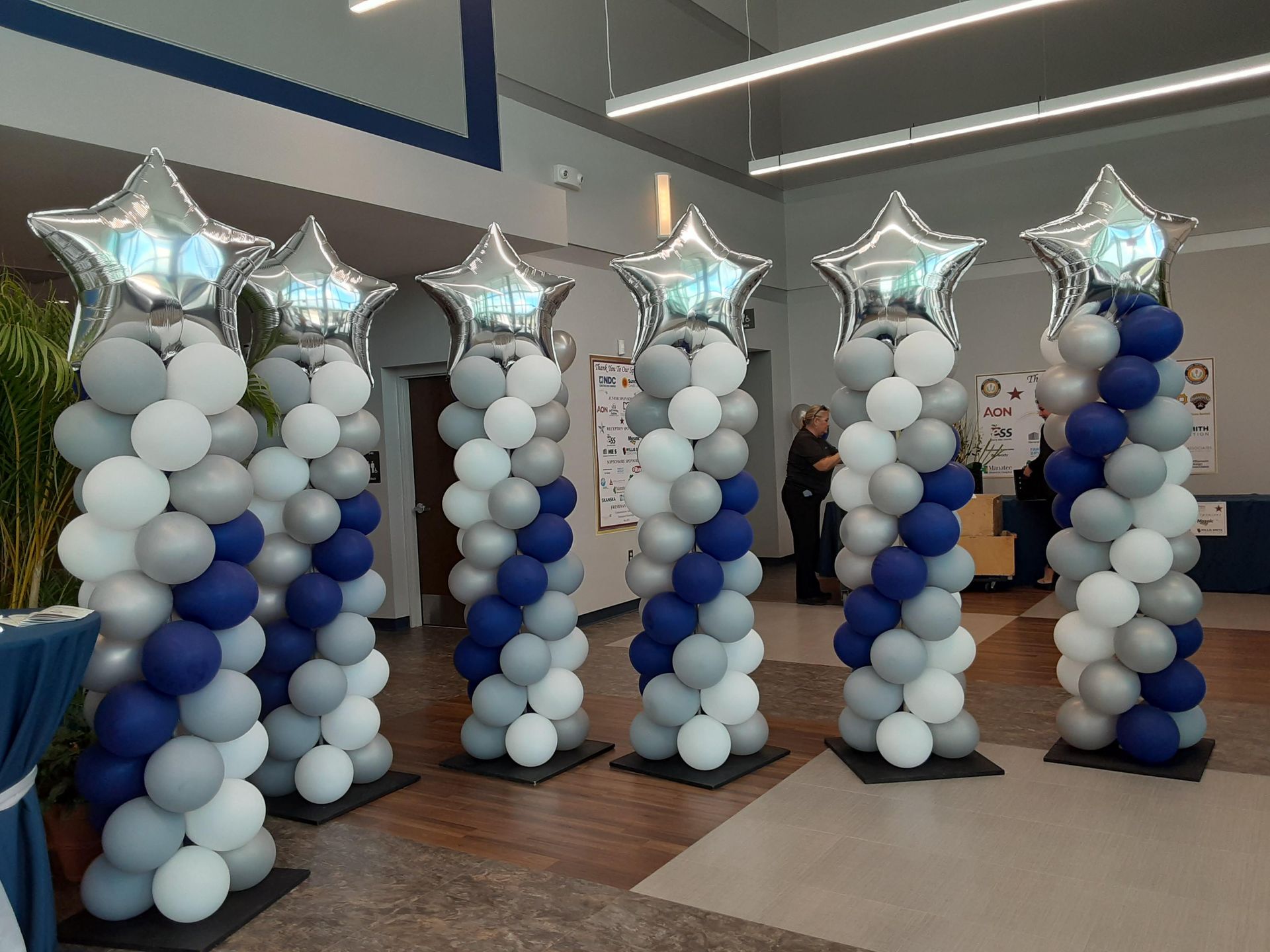 A row of balloon columns with stars on them in a room.