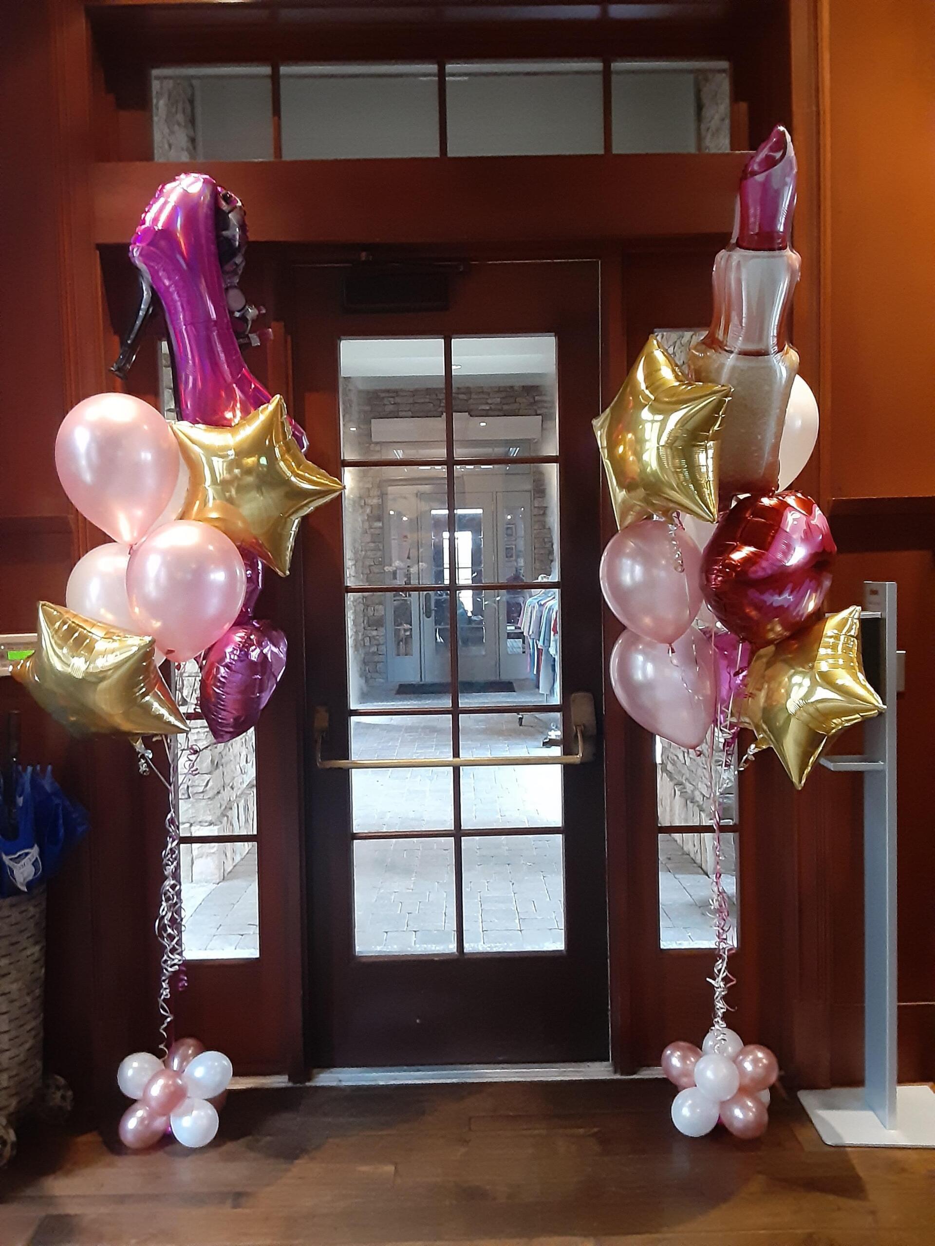 A bunch of pink and gold balloons in front of a door